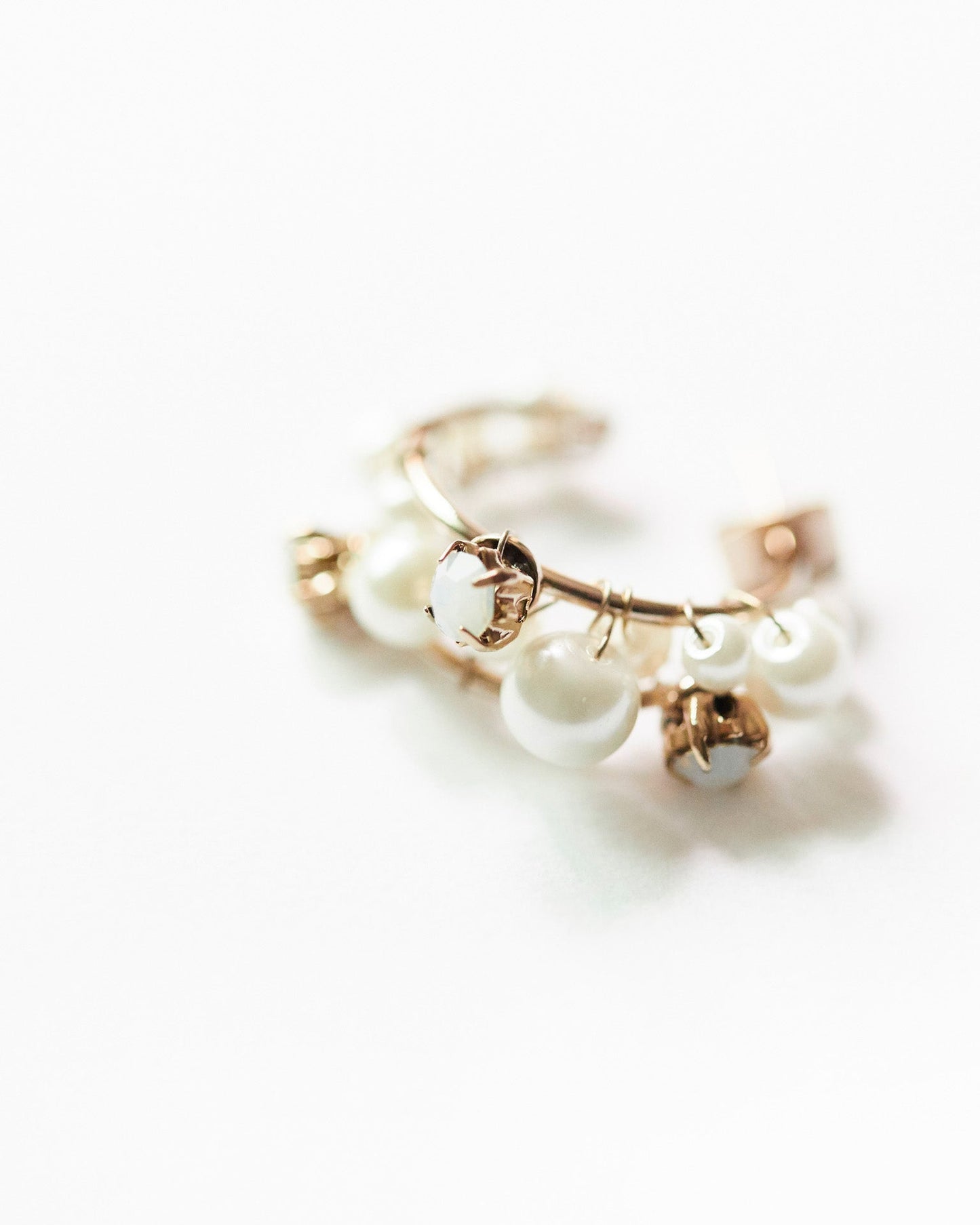 This image features a pair of elegant gemstone cascade hoops, crafted with silver 925 and 18K gold plating. The earrings are adorned with sparkling cubic zirconia stones, arranged in a twisted hoop design that enhances their allure.