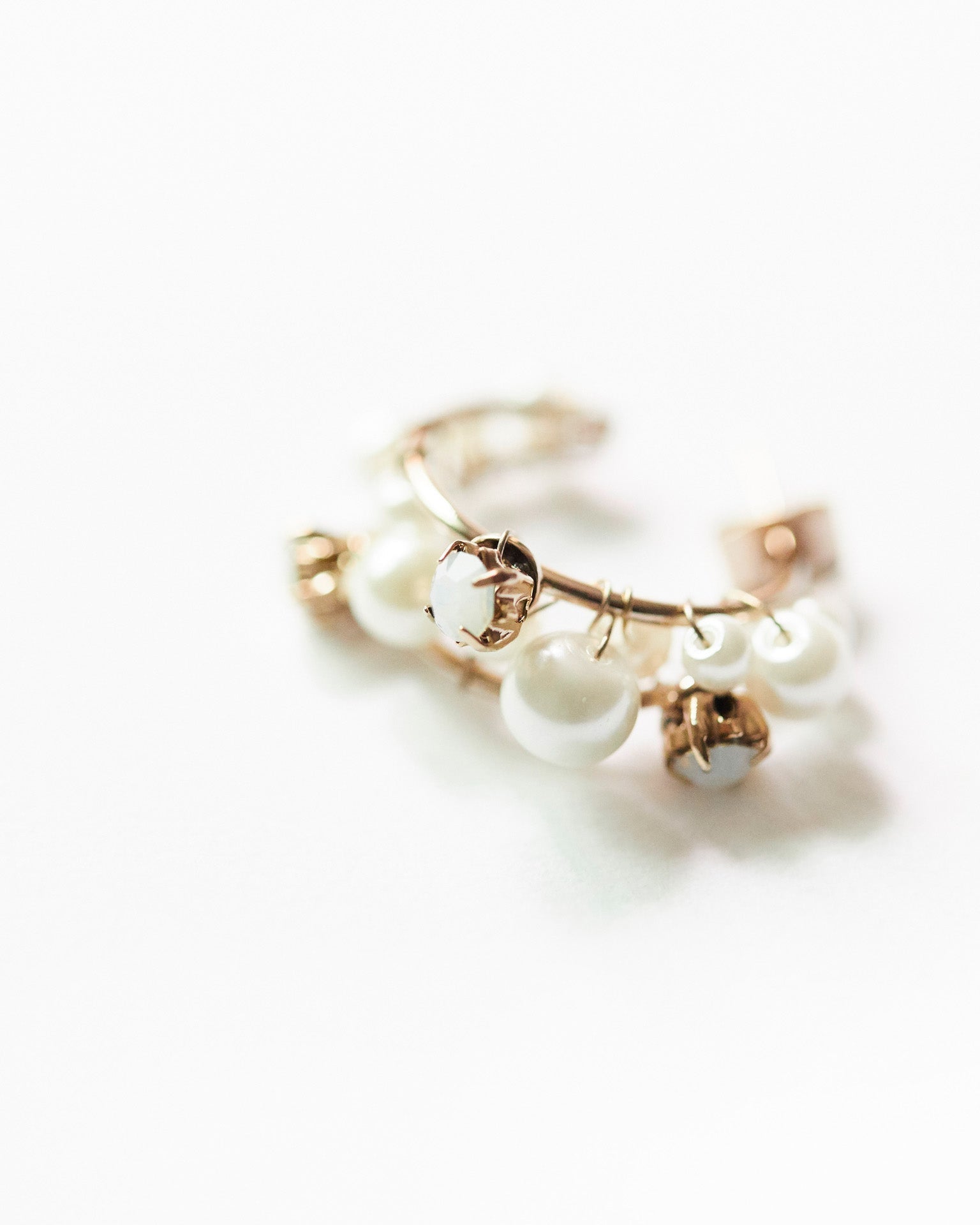 This image features a pair of elegant gemstone cascade hoops, crafted with silver 925 and 18K gold plating. The earrings are adorned with sparkling cubic zirconia stones, arranged in a twisted hoop design that enhances their allure.