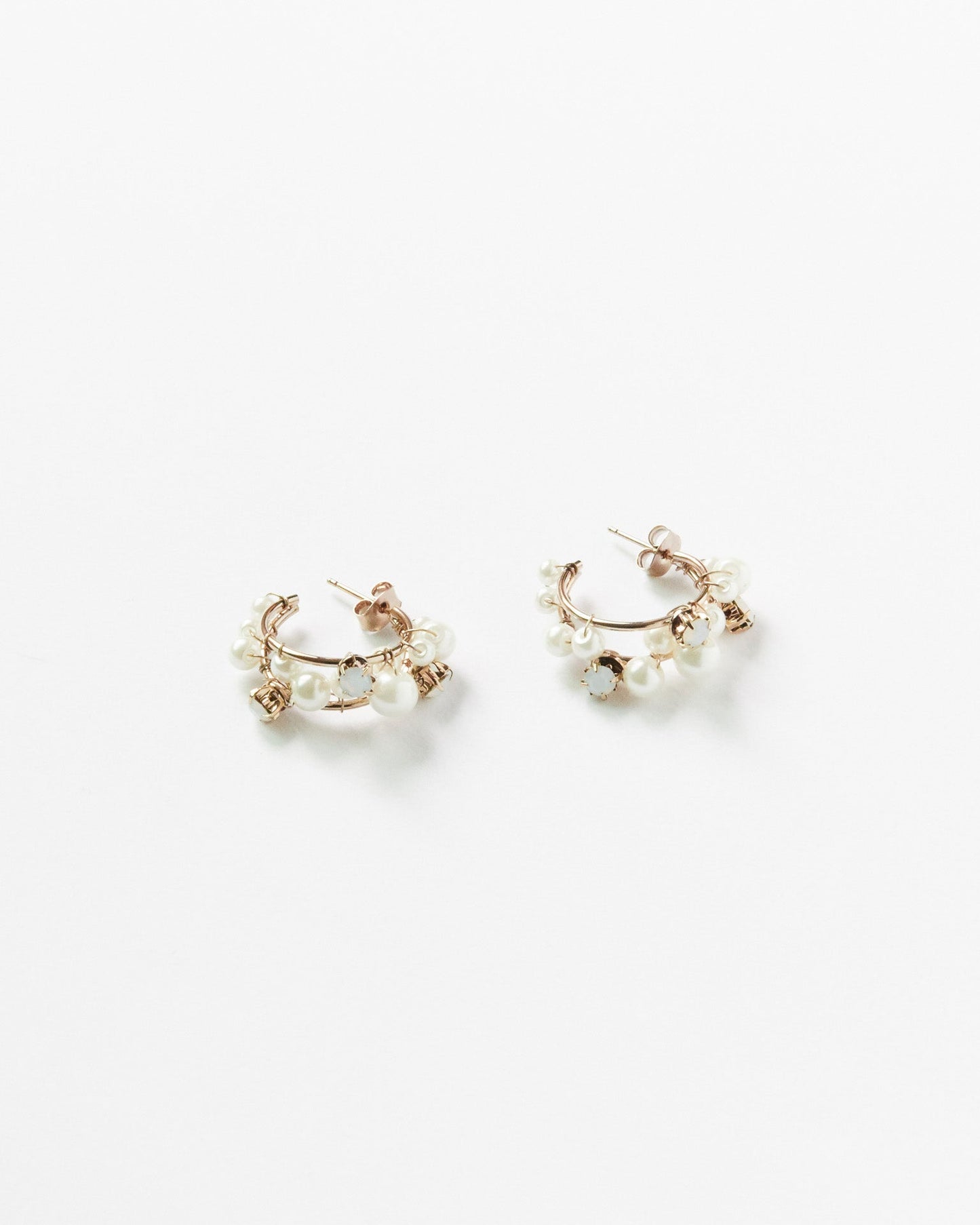 This image features a pair of elegant gemstone cascade hoops, crafted with silver 925 and 18K gold plating. The earrings are adorned with sparkling cubic zirconia stones, arranged in a twisted hoop design that enhances their allure.