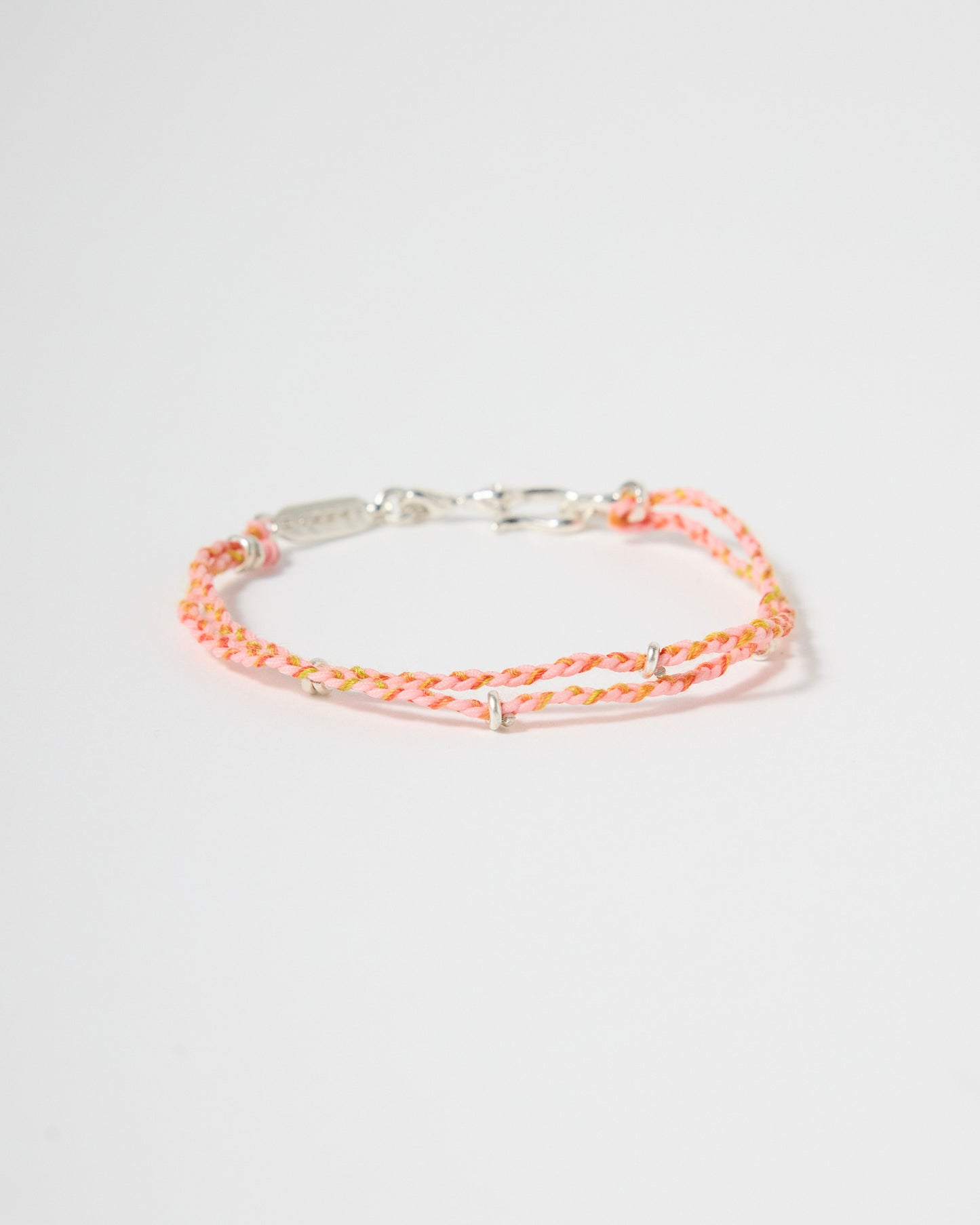Handwoven pink cord bracelet with sterling silver accents and clasp