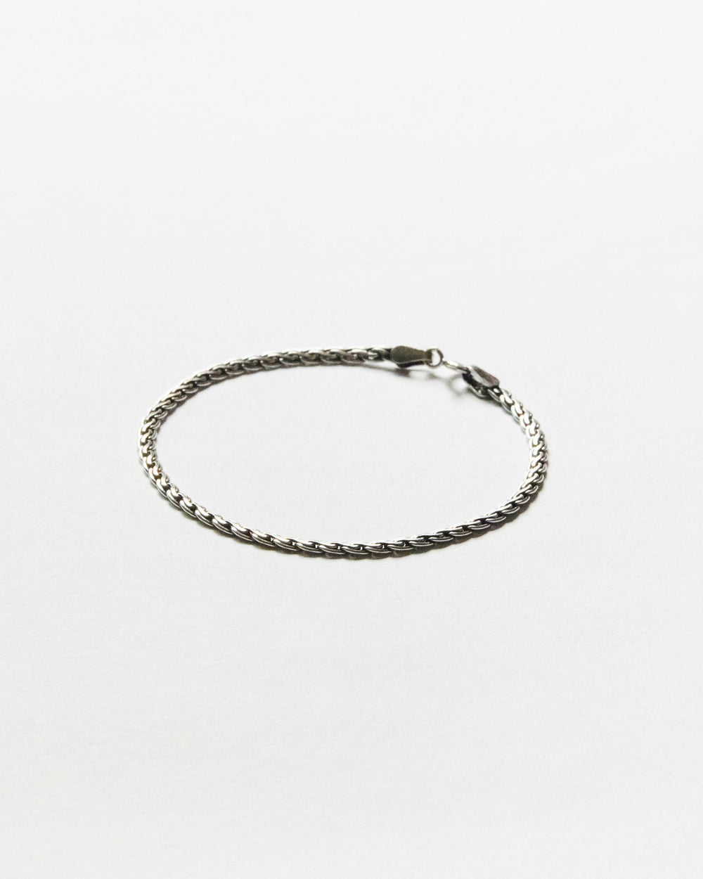 Minimal sterling silver chain bracelet featuring a refined woven link design on clean white background, designed for everyday wear and effortless layering.