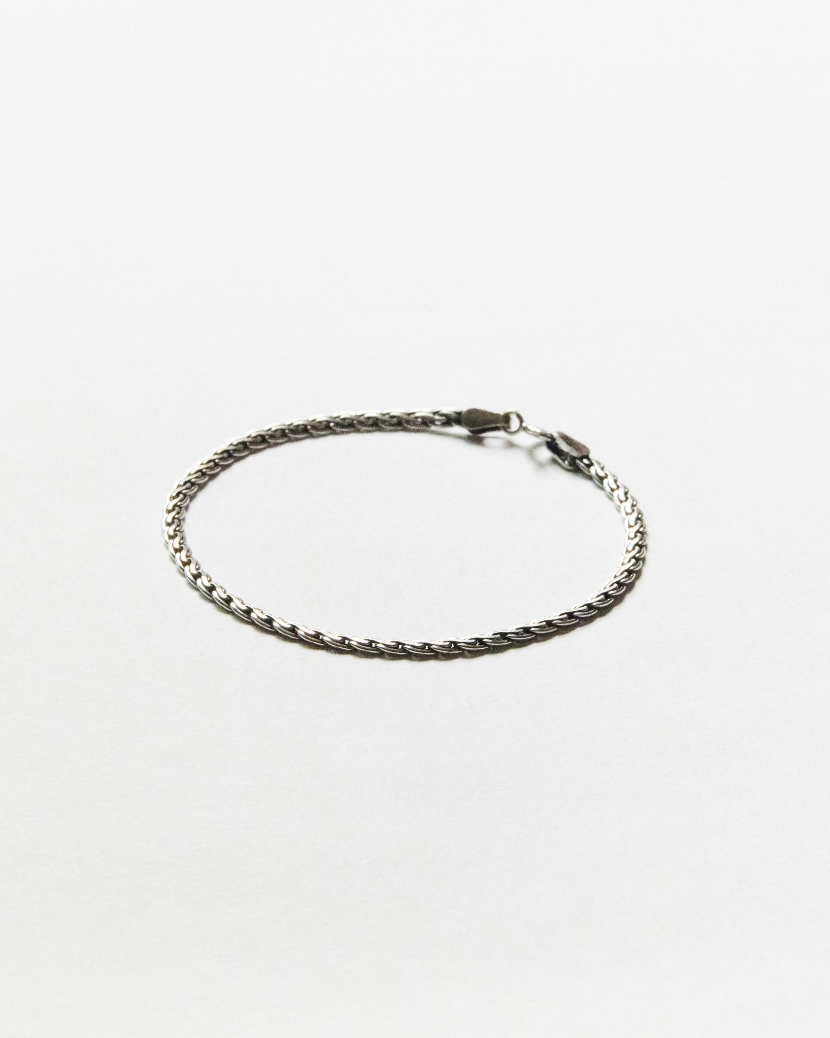 Minimal sterling silver chain bracelet featuring a refined woven link design on clean white background, designed for everyday wear and effortless layering.