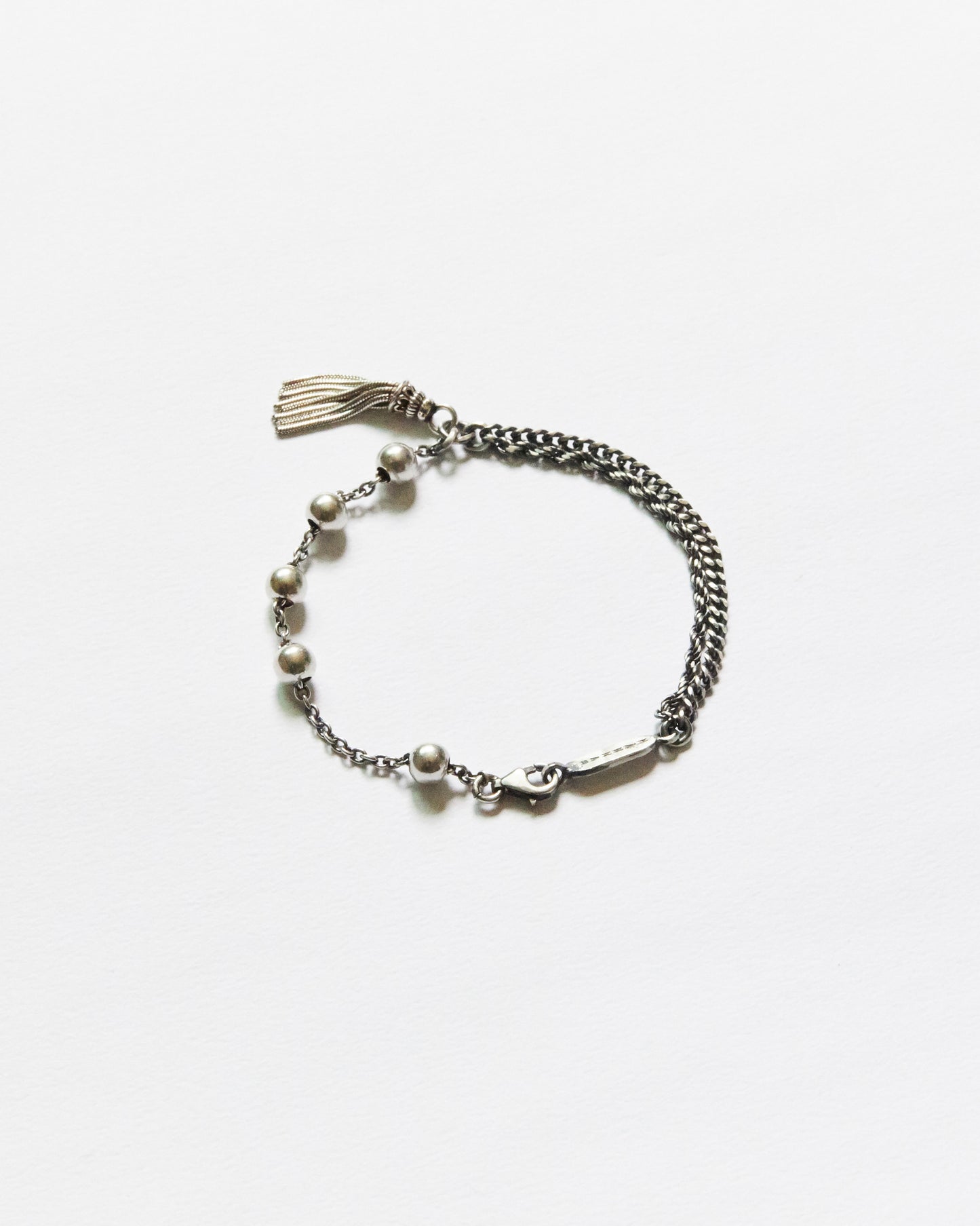 antique silver bead bracelet with tassel detail on neutral background