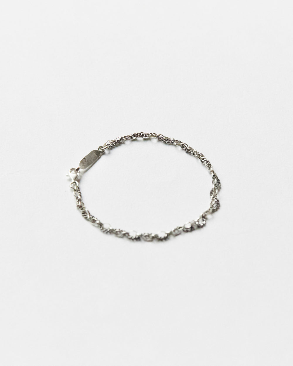 Minimal sterling silver mixed-link bracelet on white background