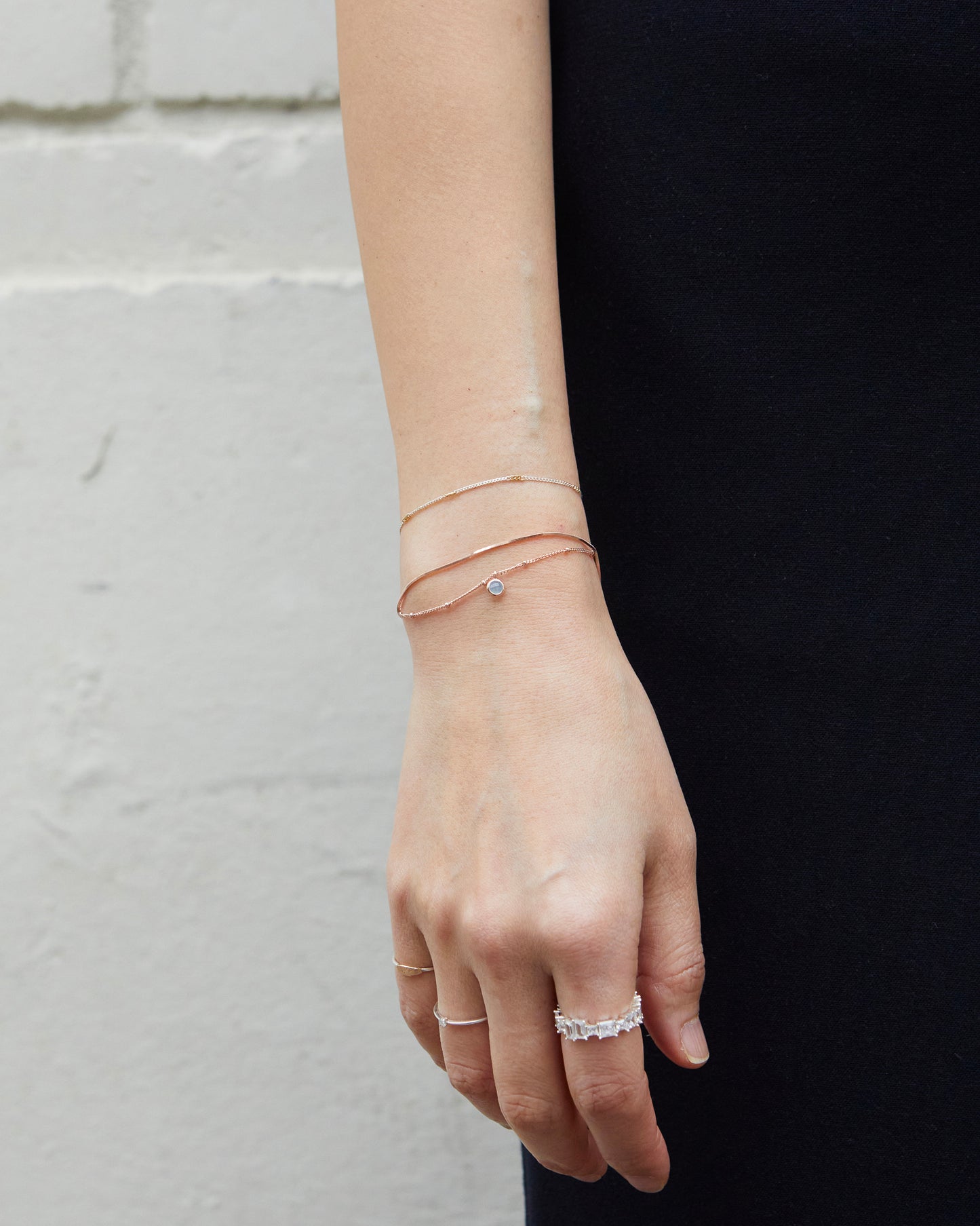 Delicate rose gold bracelet with blue gemstone styled on wrist