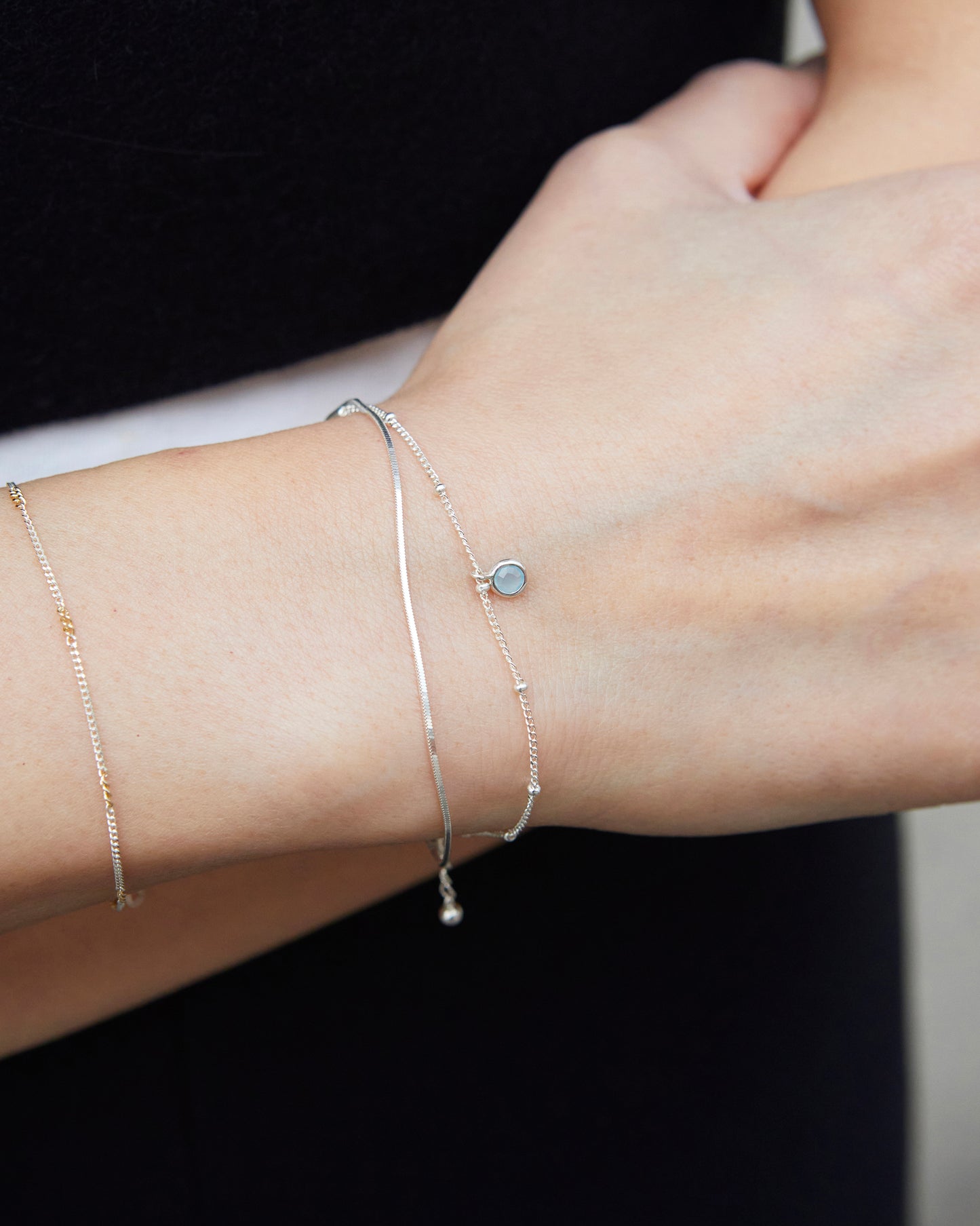 Minimal sterling silver bracelet layered with rings for everyday styling