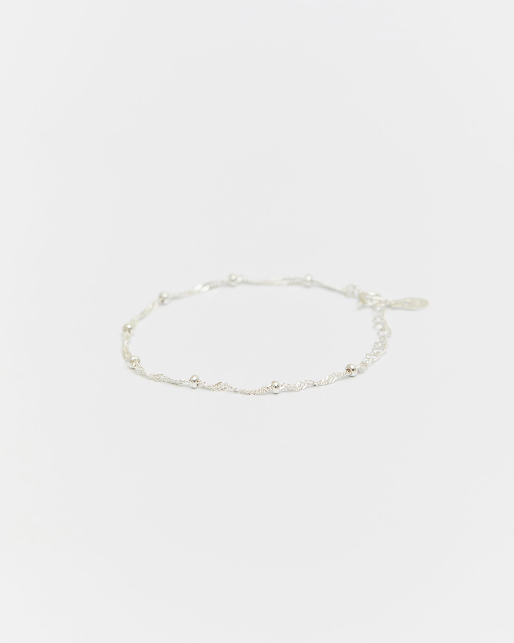 Silver chain bracelet on a light beige background