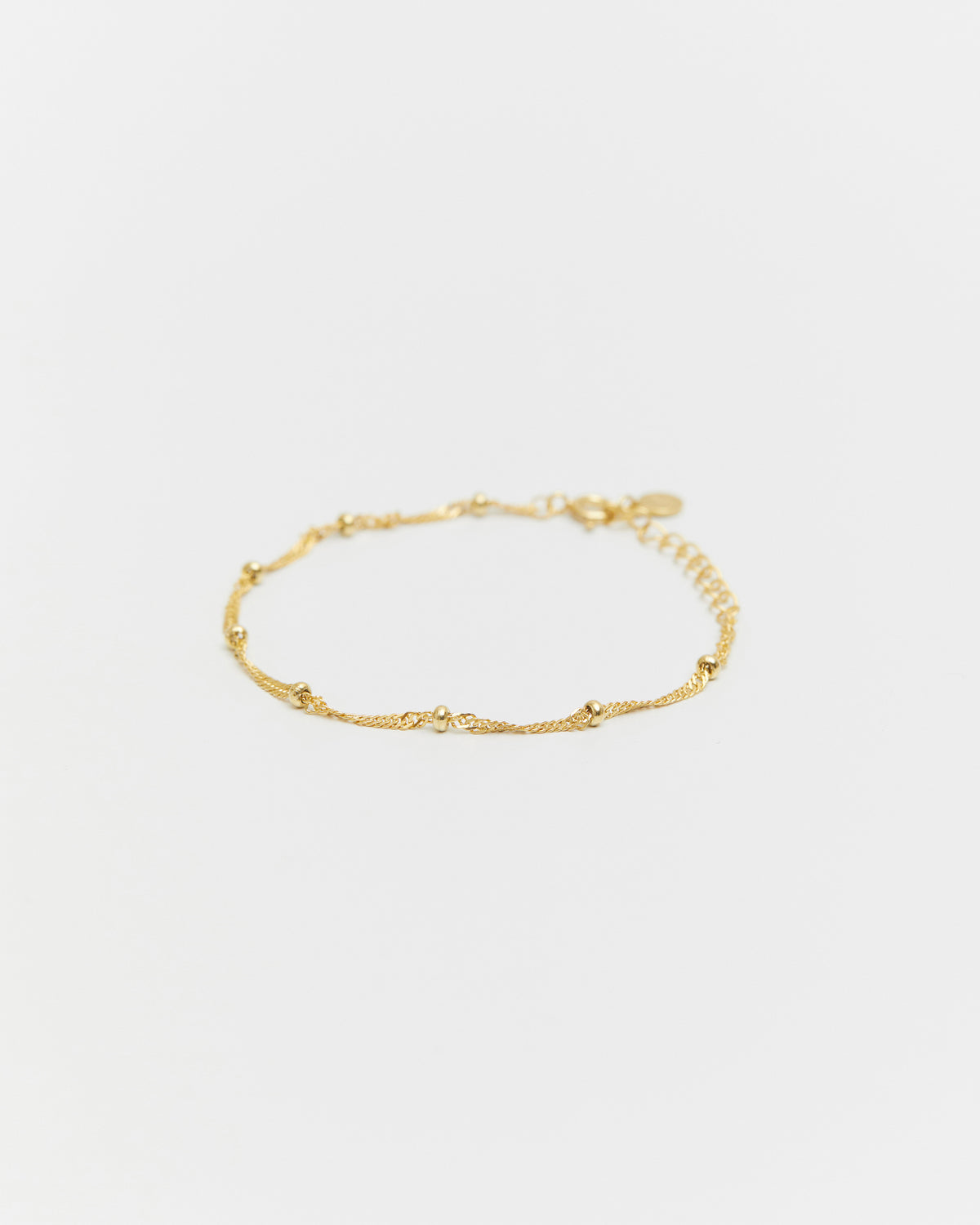 Gold bracelet on a light gray background