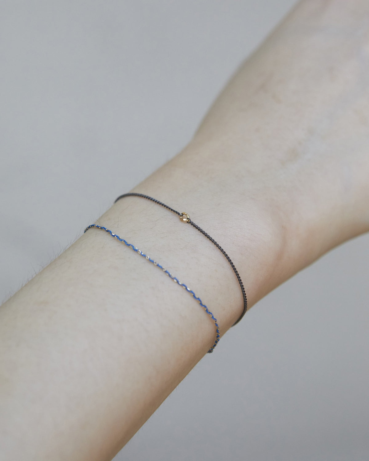 Antique silver gold-accent bracelet stacked with a blue bracelet on the wrist – HANNA543 B535 gold note chain