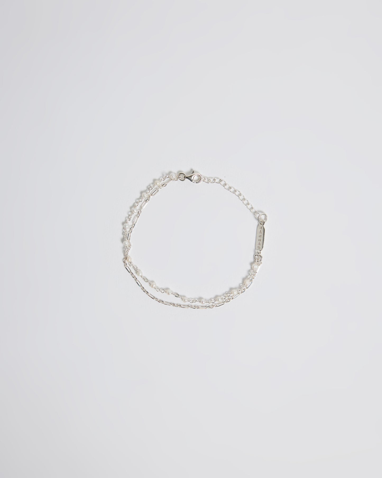 Top view of silver layered pearl bracelet with delicate chain and tiny pearl details