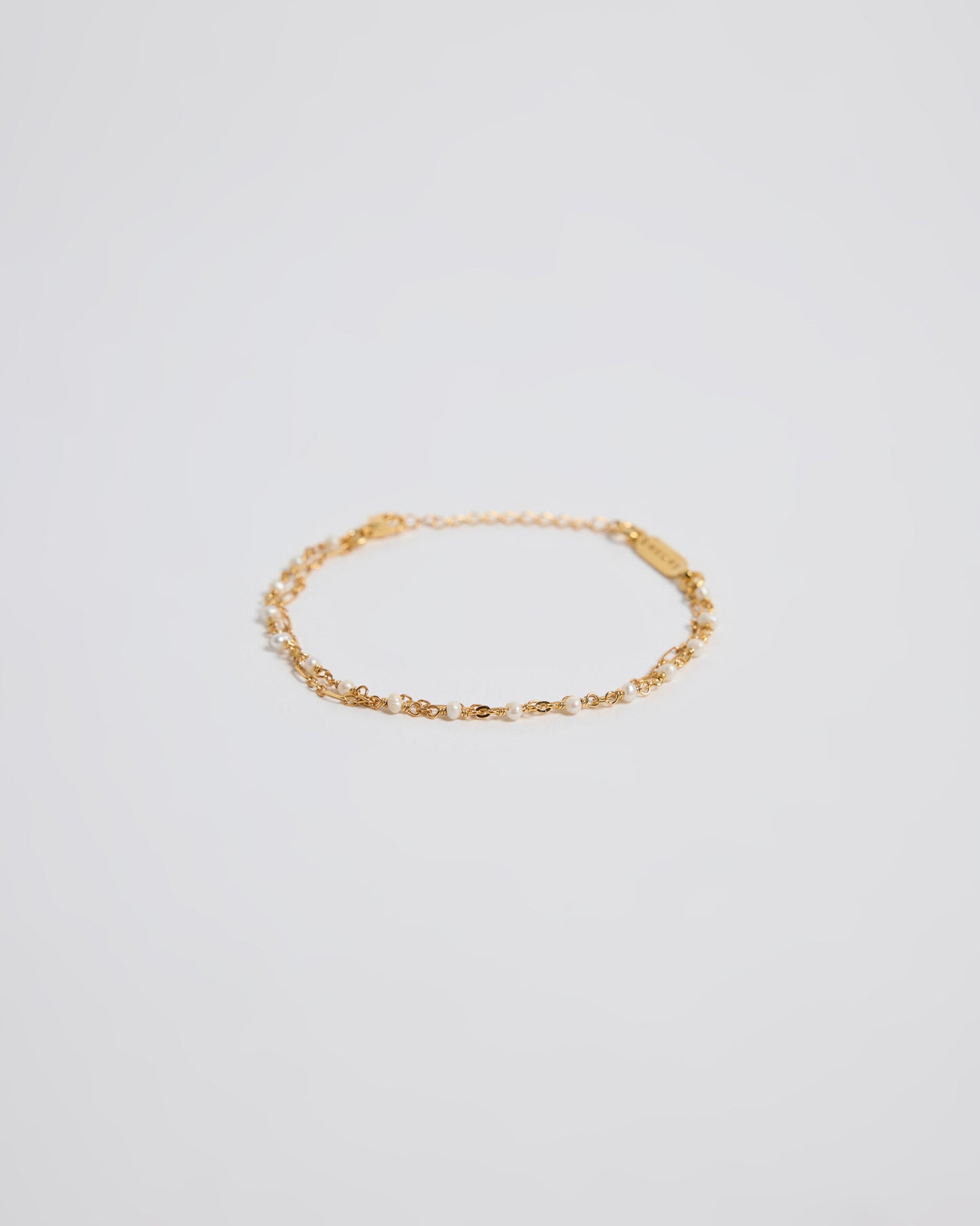 Minimal double layered gold pearl bracelet isolated on white background