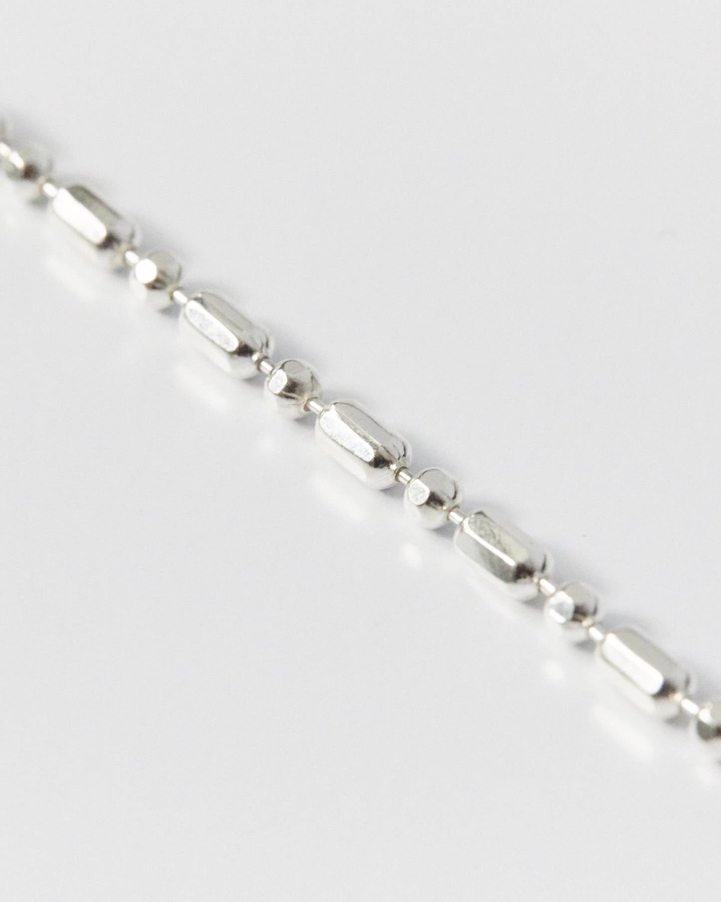 design-forward silver bracelet featuring repeated geometric links and polished finish