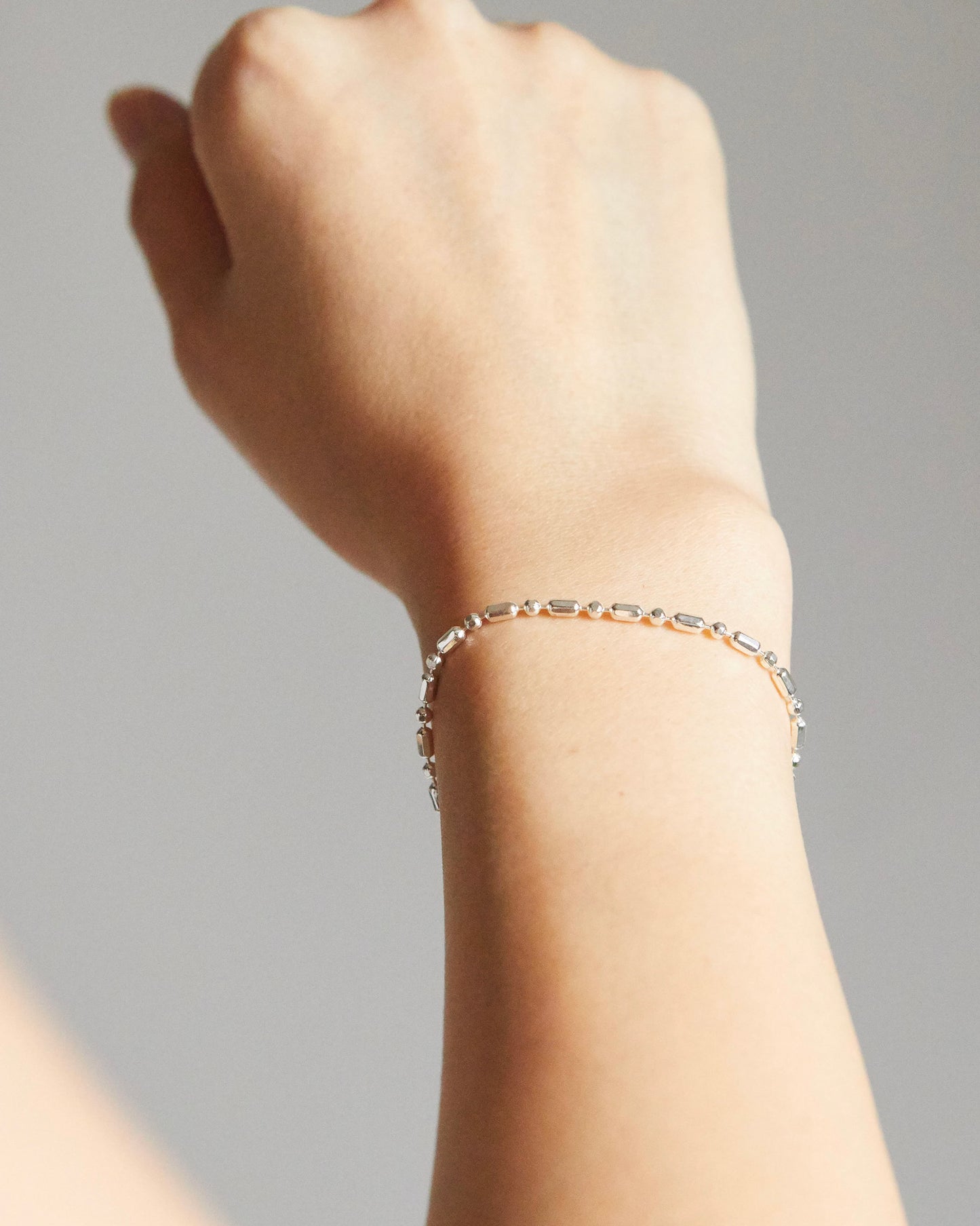 minimal silver bead and bar bracelet with structured rhythm and fluid movement
