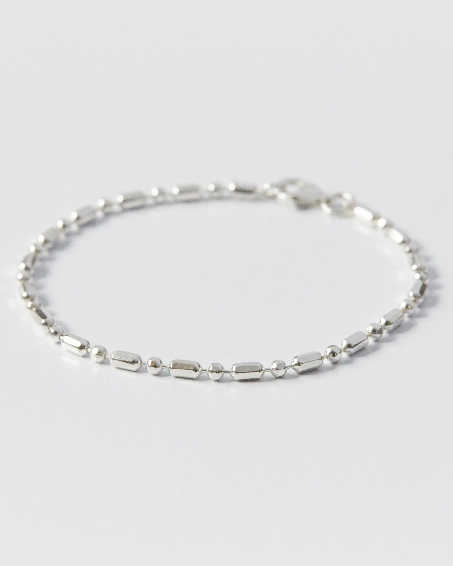 silver bracelet composed of modular bead and bar elements, clean and balanced form