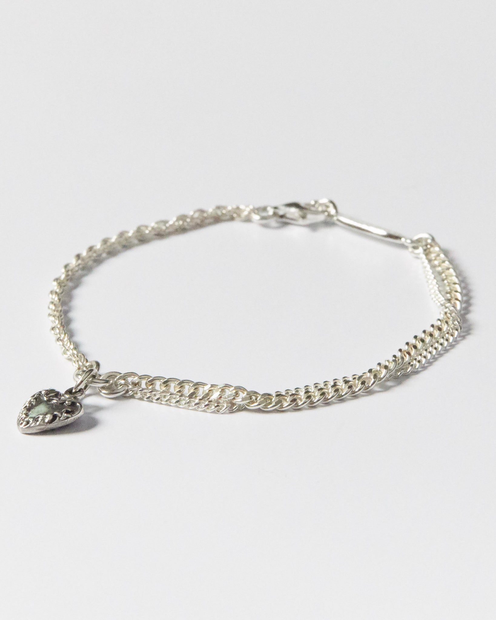 925 silver bracelet with double chain and vintage-style heart charm on white background
