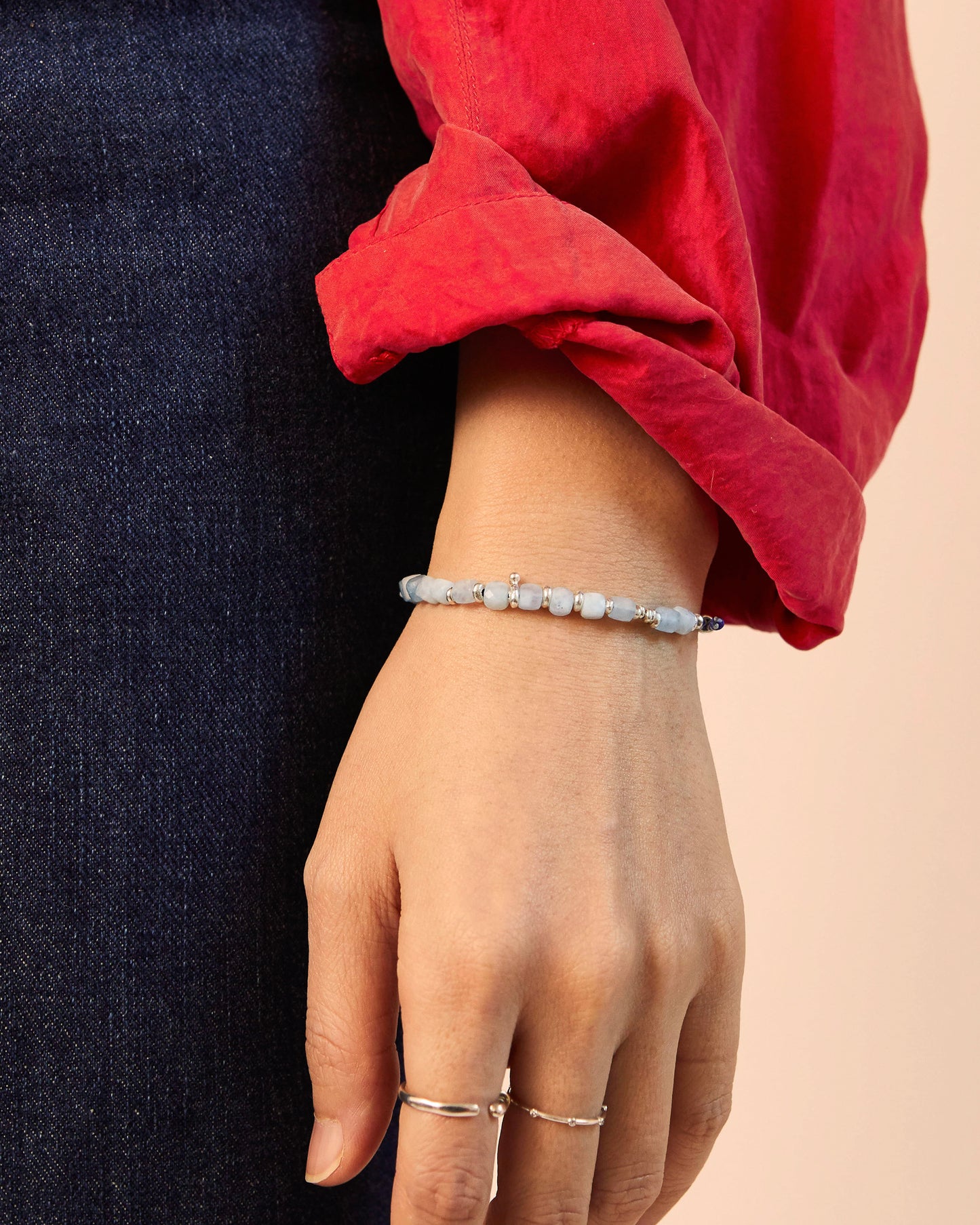 Styled wrist shot showing layered bracelets with soft colors