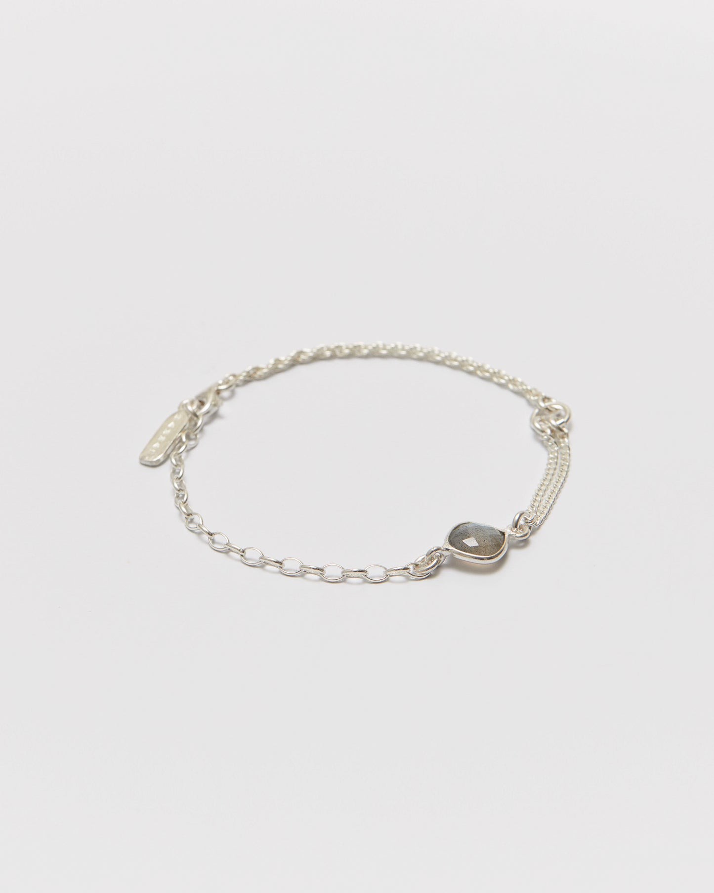 Silver bracelet with a central gemstone on a light gray background