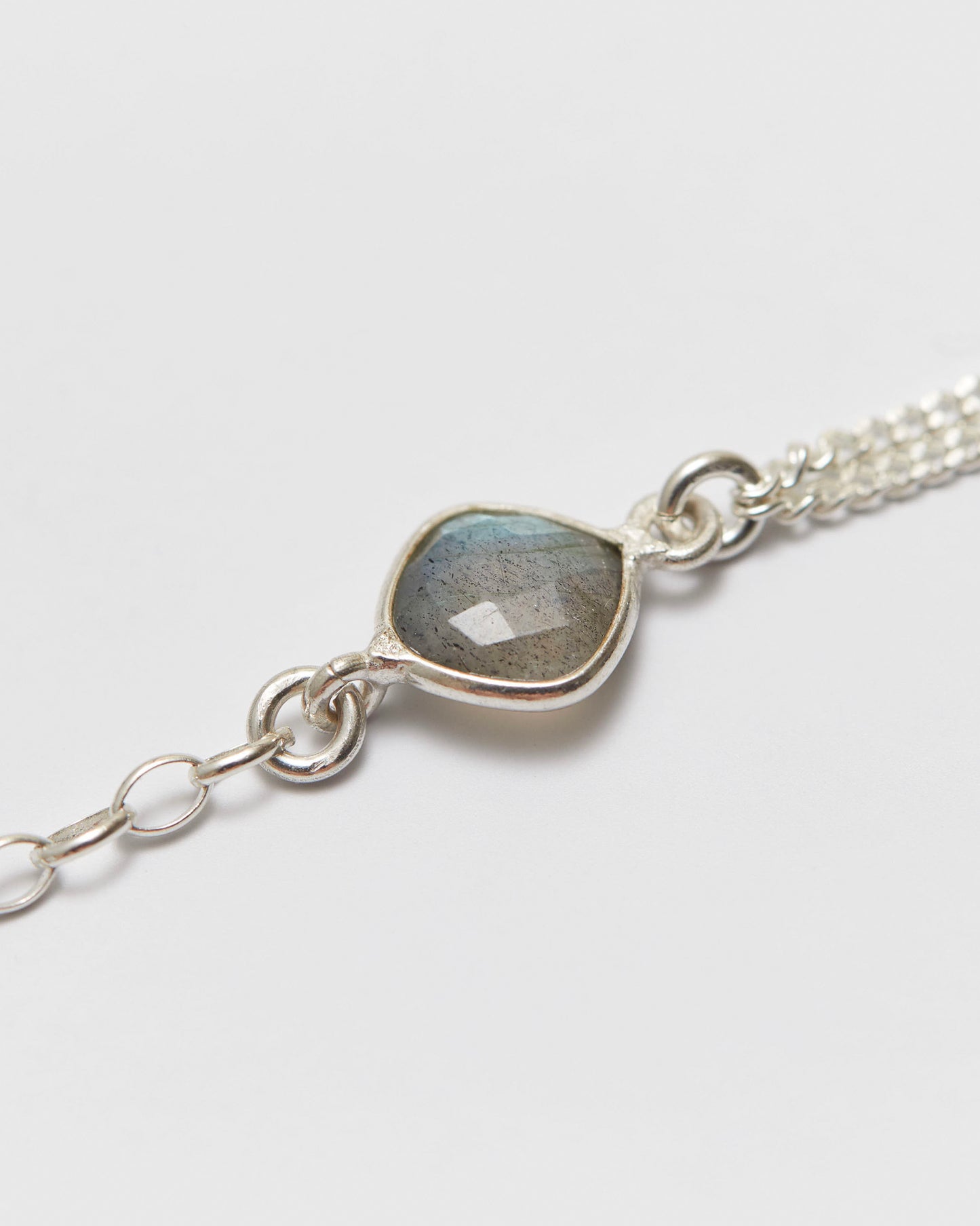 Silver bracelet with a labradorite stone on a white background