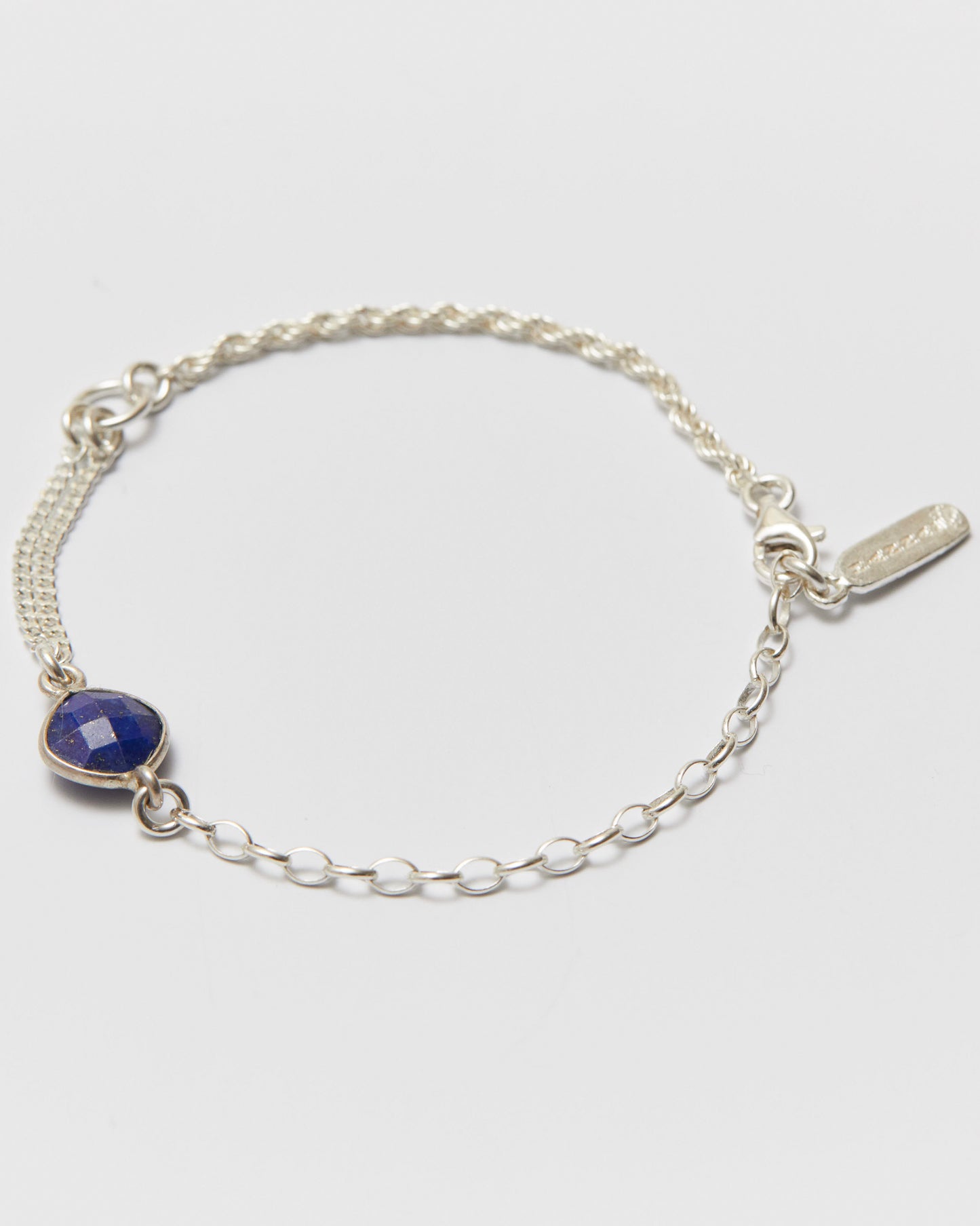 Silver bracelet with a blue gemstone on a white background