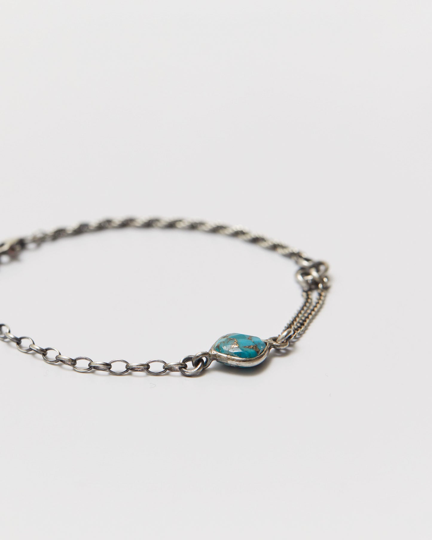 antique silver bracelet with a turquoise stone on a white background