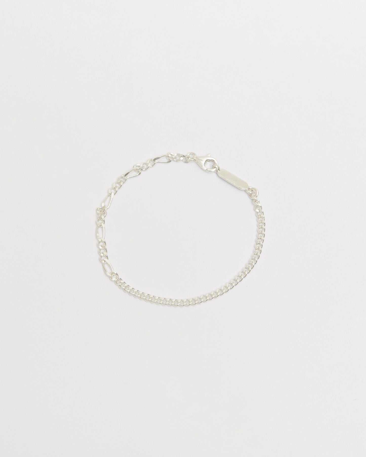 Sterling silver mixed link bracelet featuring alternating elongated and curb chain details with polished finish on white background.