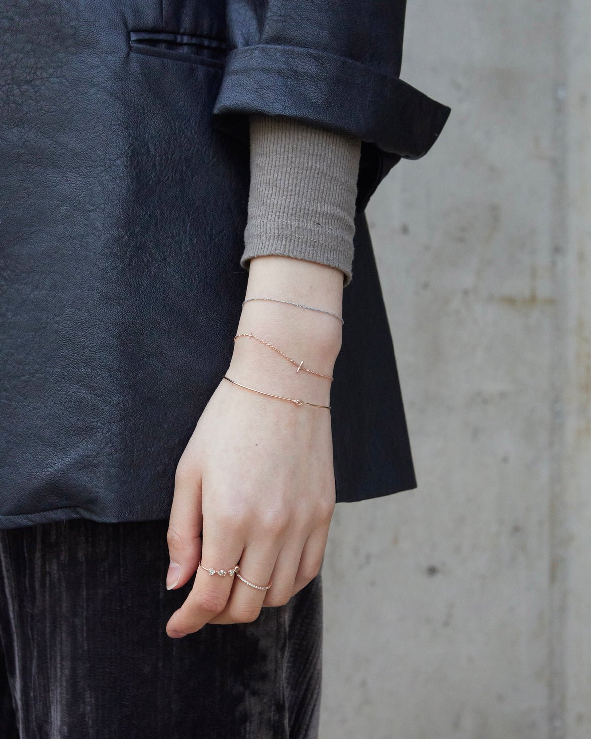 cross axis chain bracelet in pink gold – stacked on the wrist, styled with a dark jacket | HANNA543