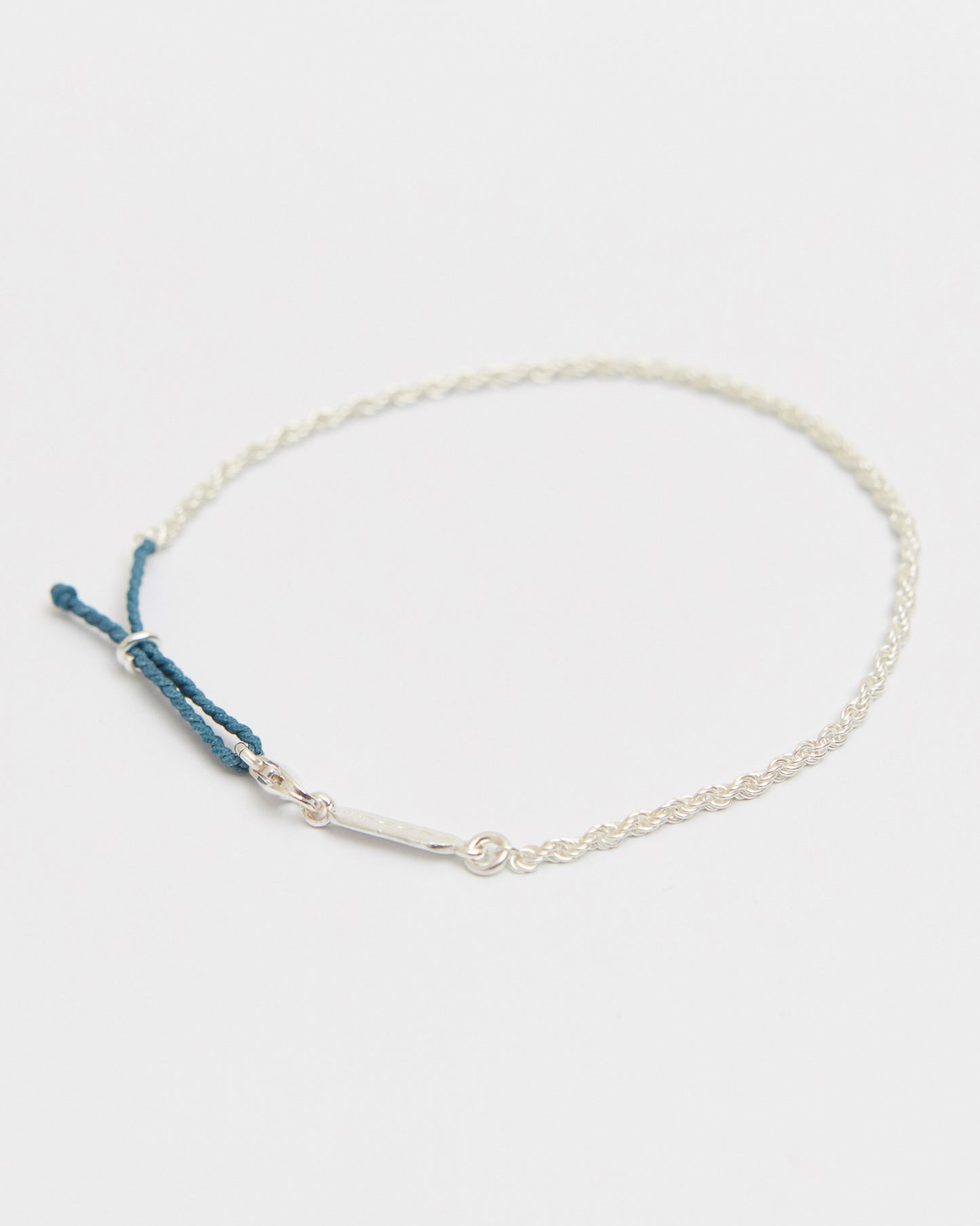 Minimal sterling silver bracelet featuring braided vintage green cord detail and delicate silver chain for everyday wear.