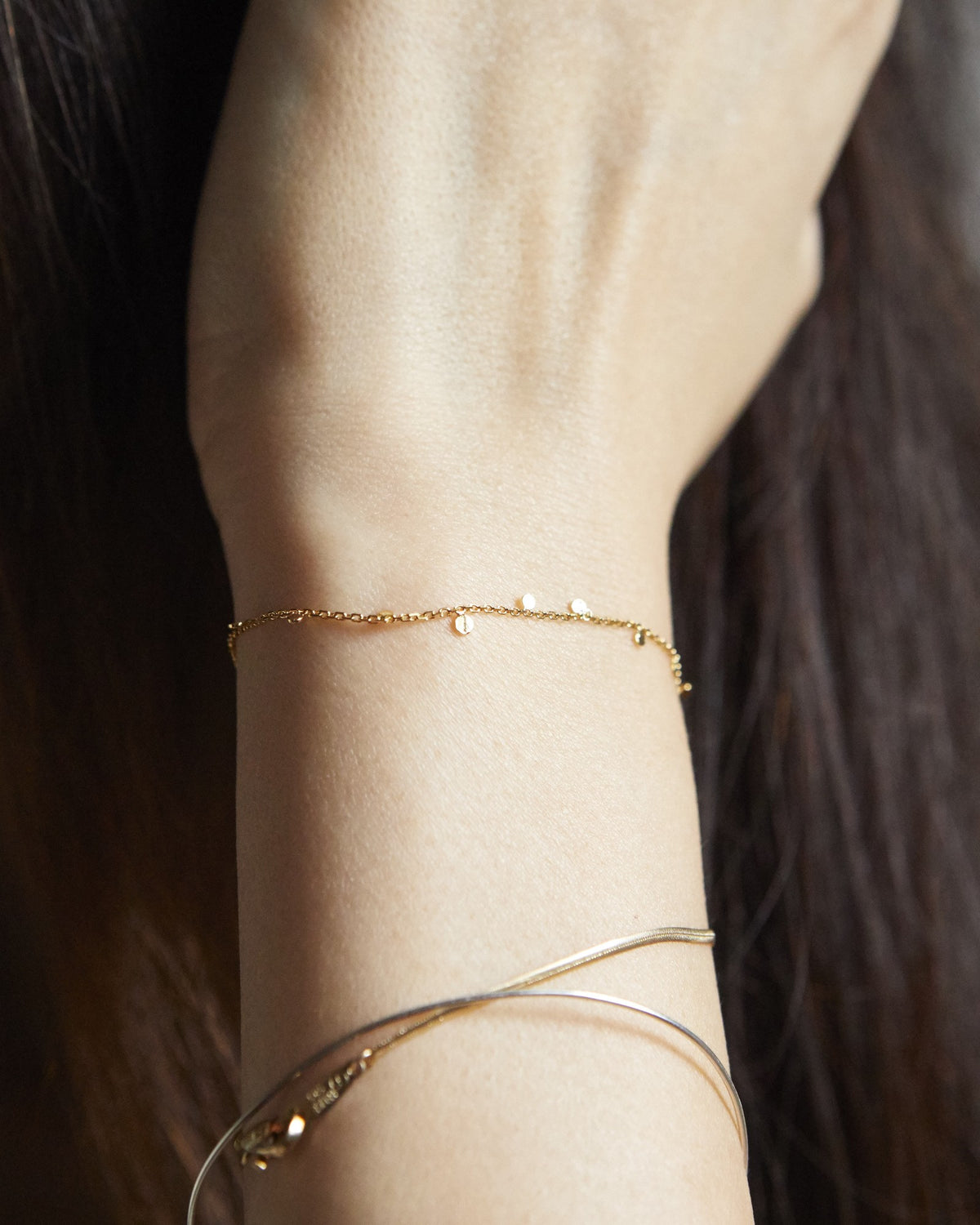 Wrist wearing a dainty gold dot chain bracelet – HANNA543 B96 dew drop garland