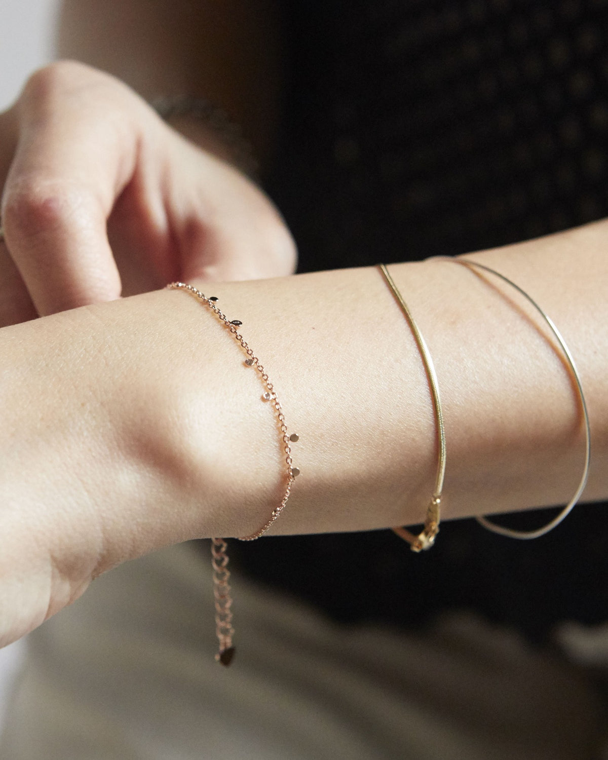 Pink gold dot chain bracelet layered with thin bangles on the wrist – HANNA543 B96 dew drop garland