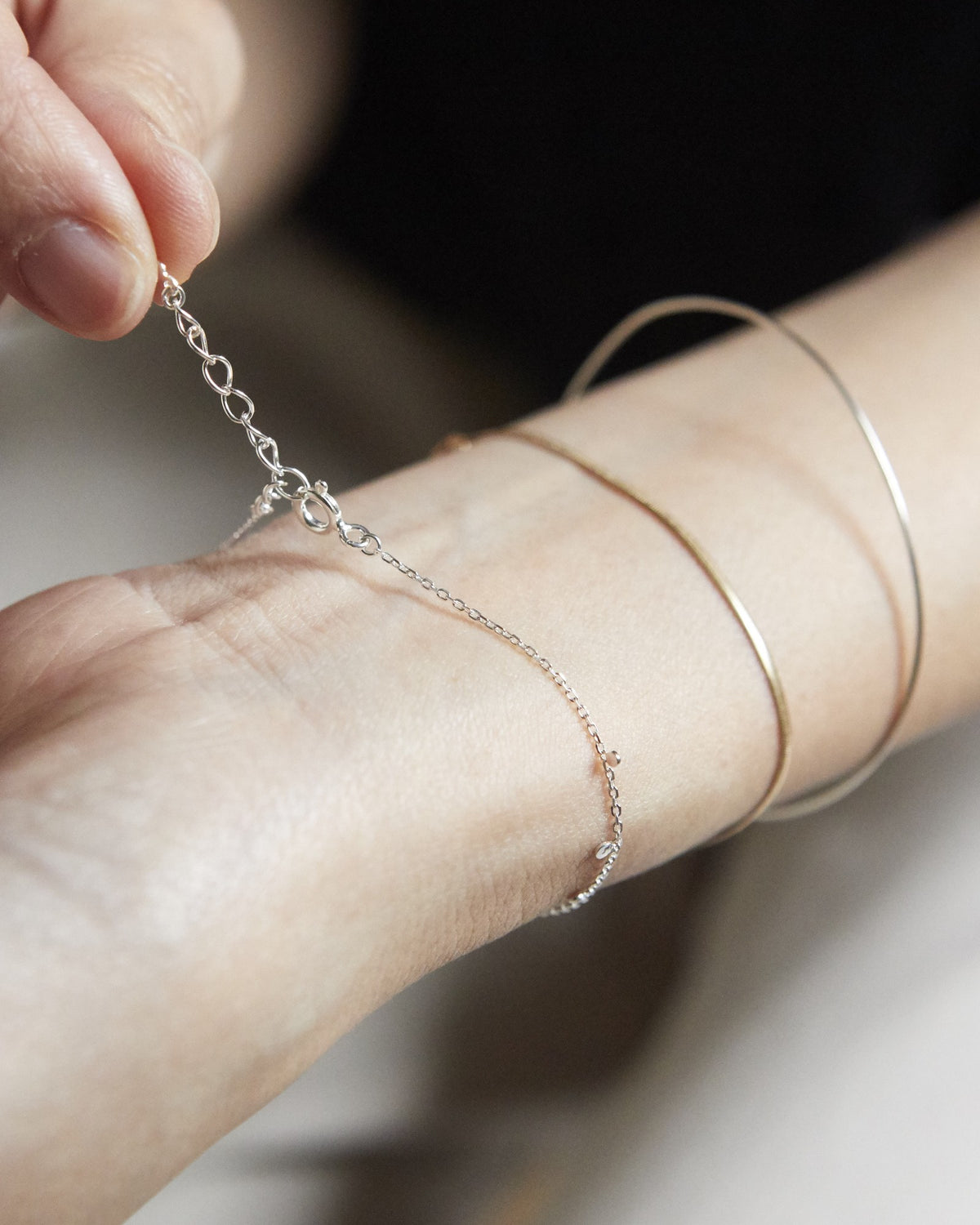 Hand fastening a silver dot chain bracelet with extender chain – HANNA543 B96 dew drop garland
