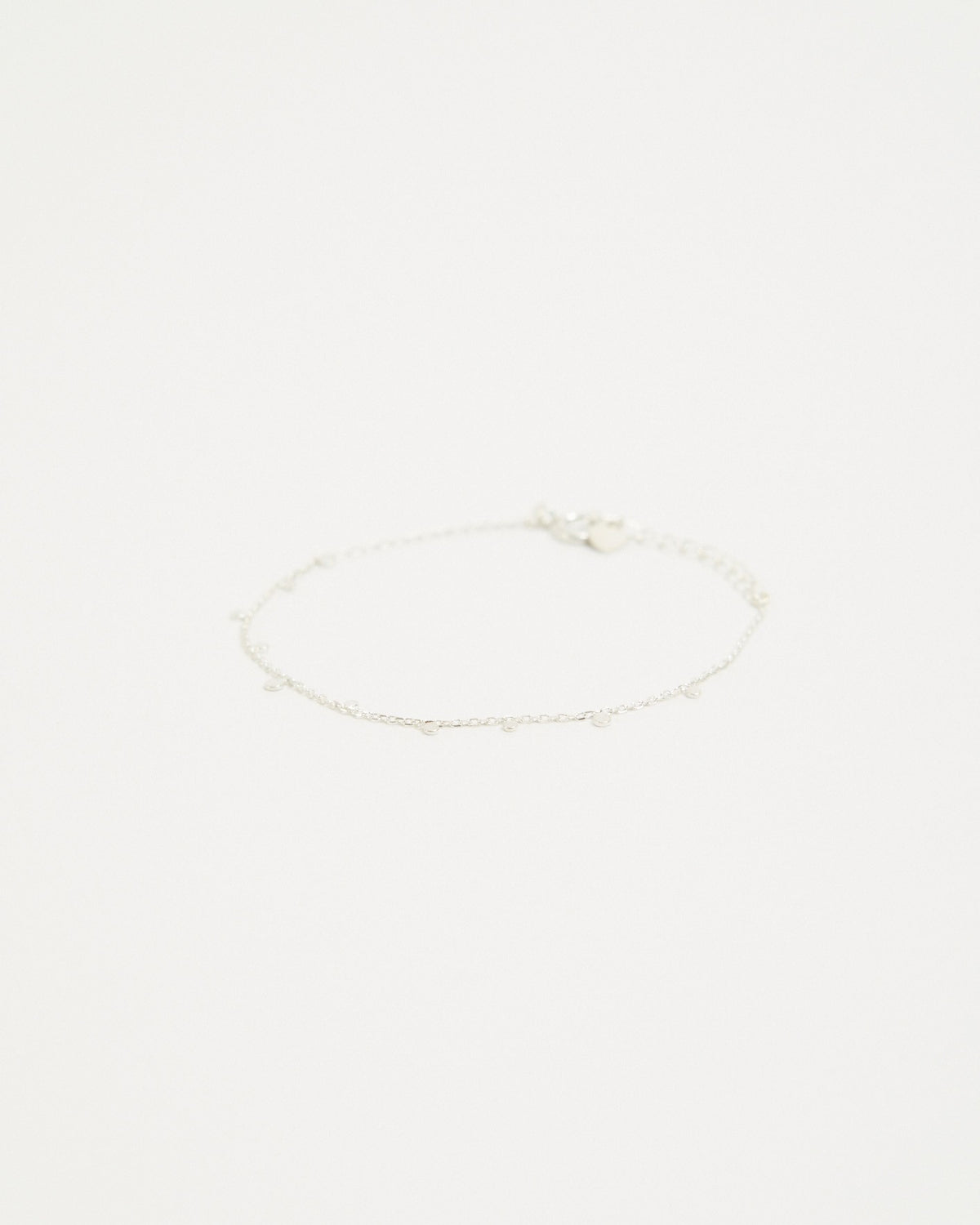 Sterling silver dot station chain bracelet laid flat on a light background – HANNA543 B96 dew drop garland