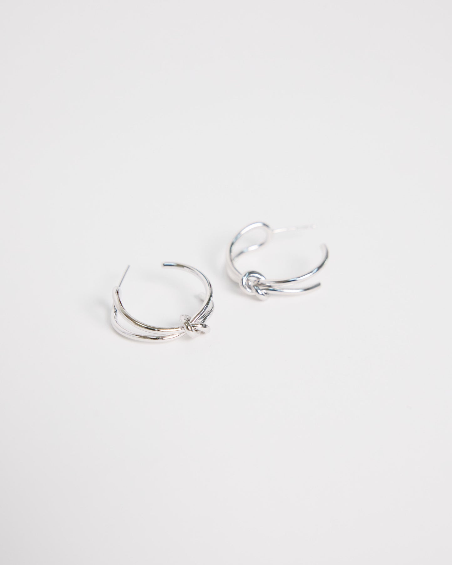 pair of silver hoop earrings on a light gray background