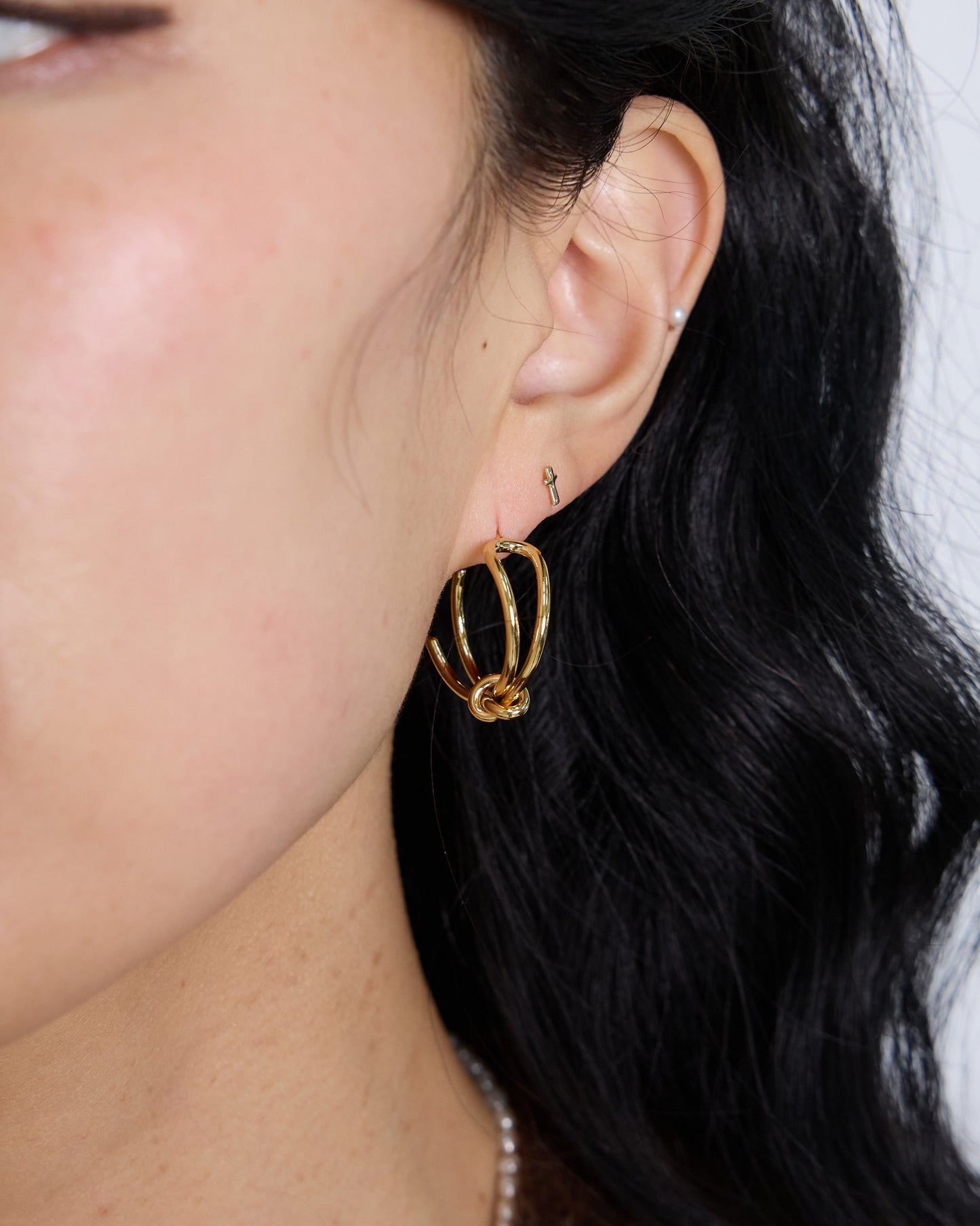 gold double hoop knot earrings close up modern sculptural design gold plated minimal statement earrings