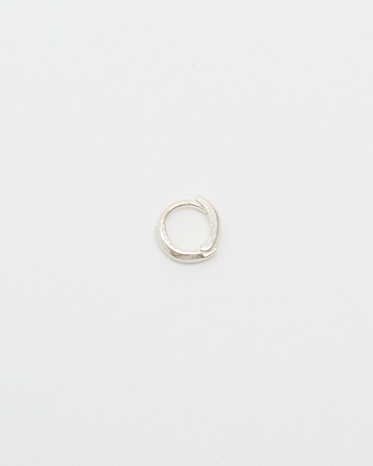 Small 5mm silver huggie hoop earring on a light gray background – HANNA543 E155 soft halo huggie