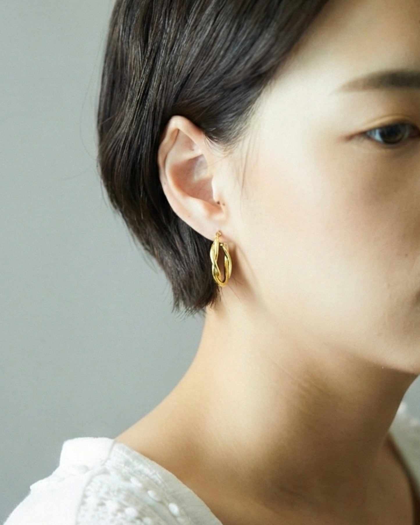styling of HANNA543 E324 twisted gold hoop earrings on ear. daily minimalist jewelry look inspired by BTS JIMIN