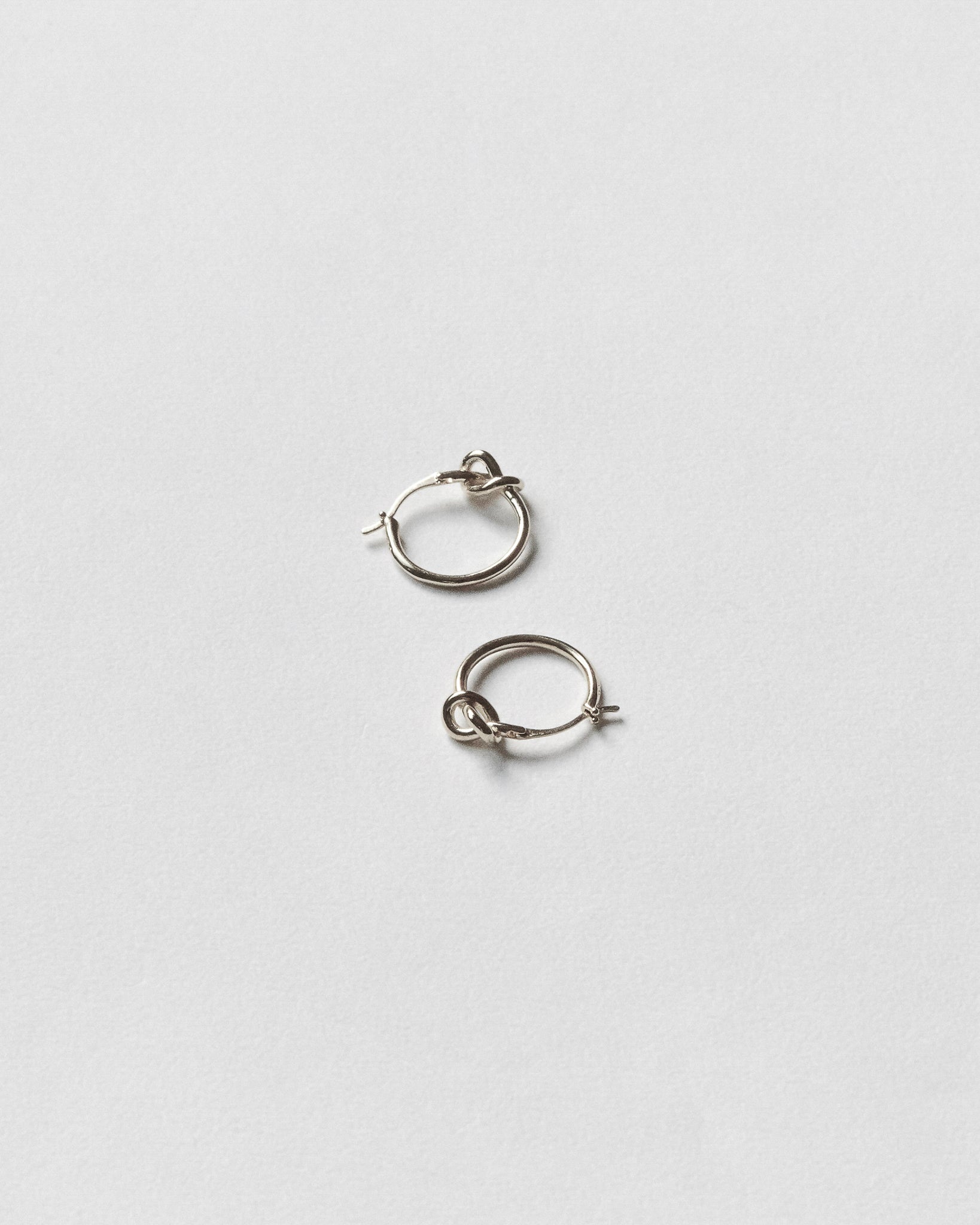 Pair of silver hoop earrings on a light gray background