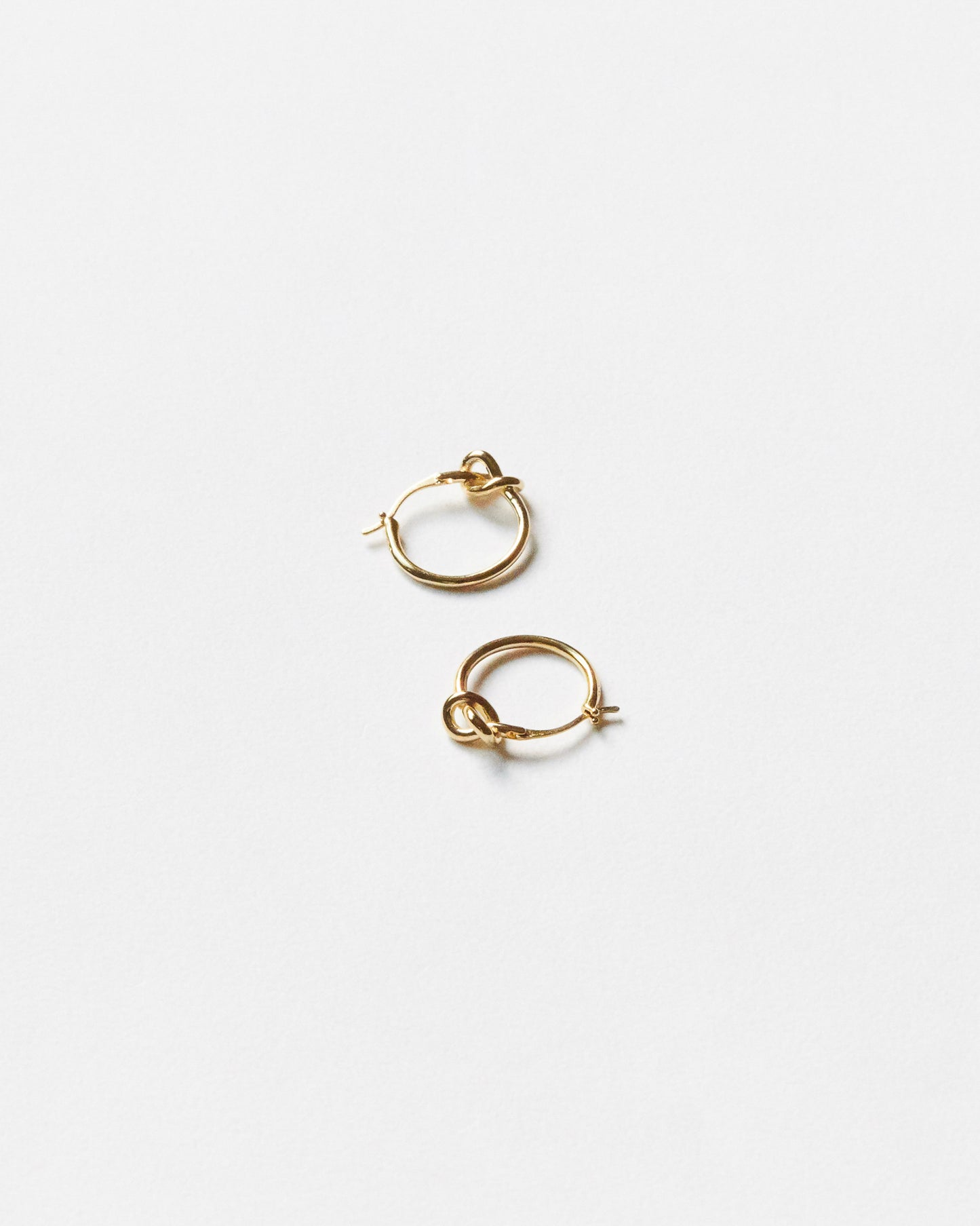 Gold hoop earrings on a light gray background