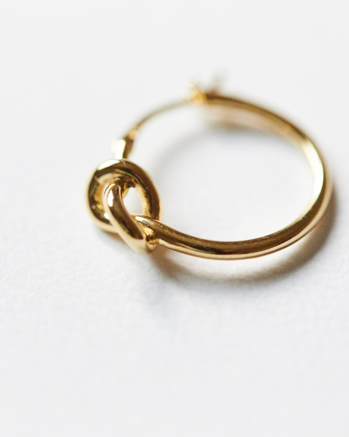 Gold hoop earring on a white background