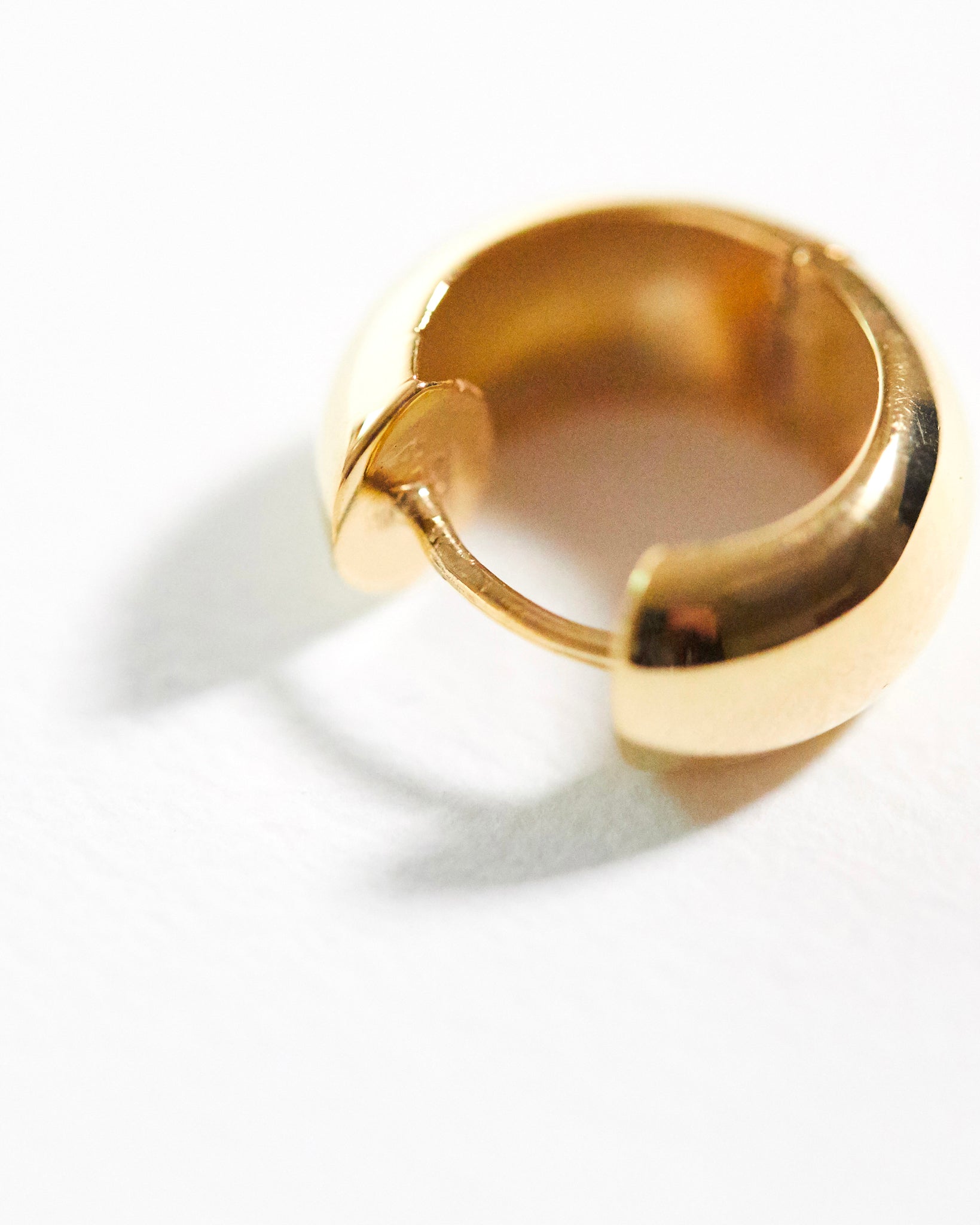 detail gold hoop earring on a white background