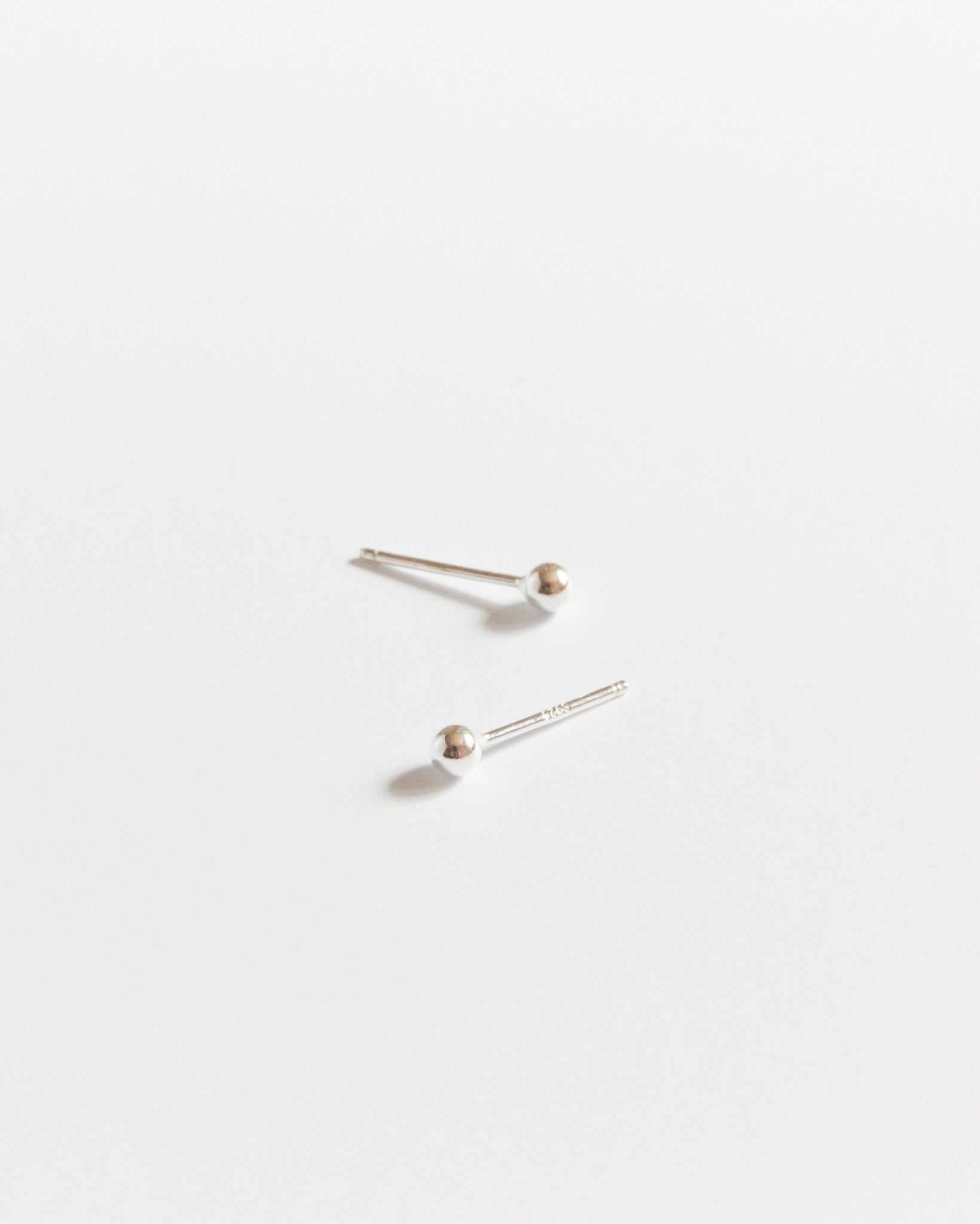 Pair of gold stud earrings on a white background