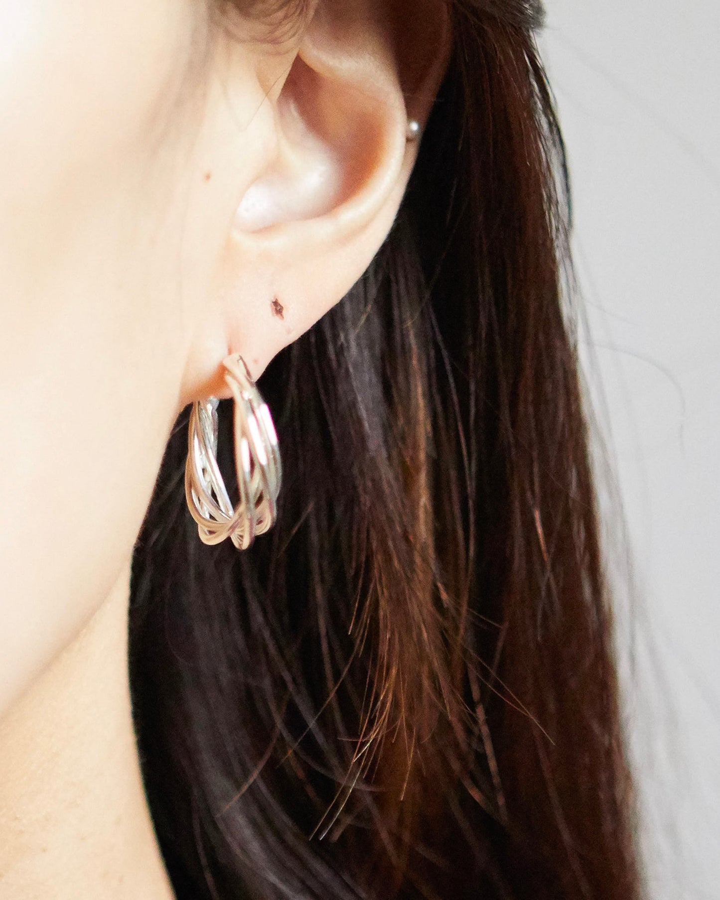 styling of HANNA543 E783 silver spiral earrings on ear. minimalist unisex jewelry look inspired by BTS JIMIN style