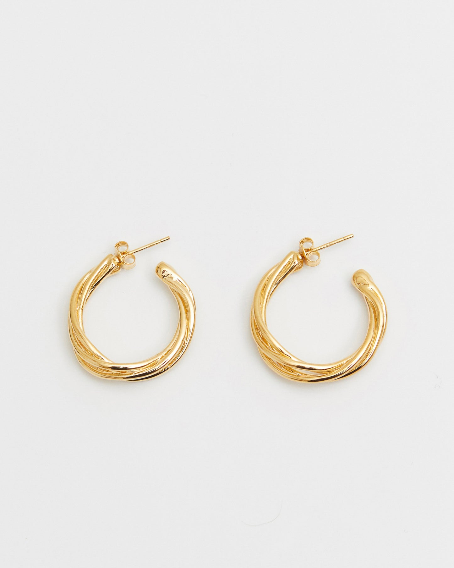 Gold hoop earrings on a light gray background
