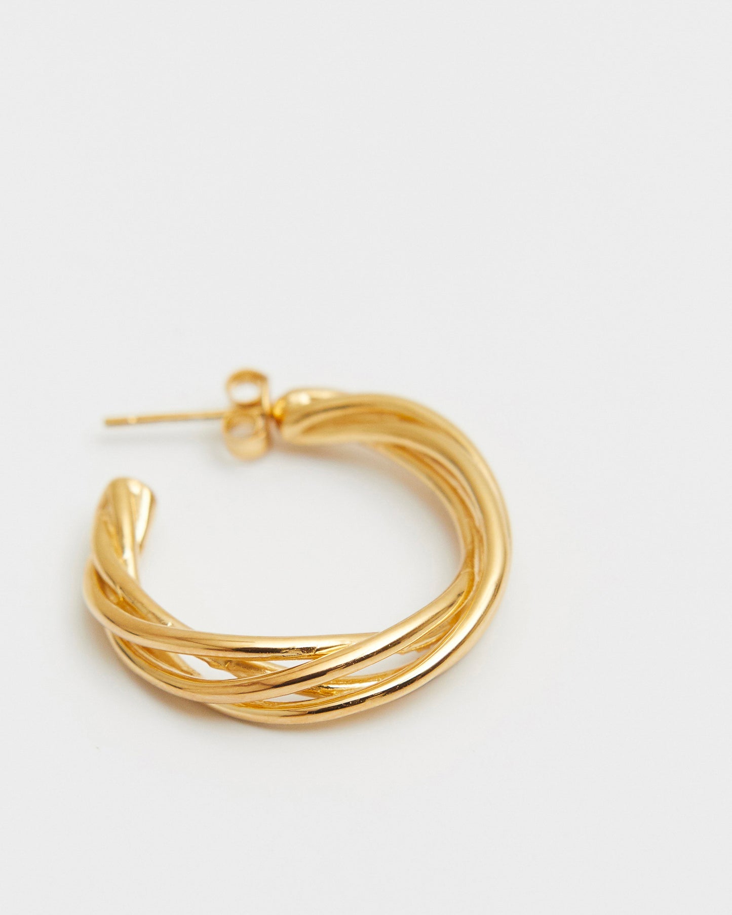 Gold hoop earring on a white background