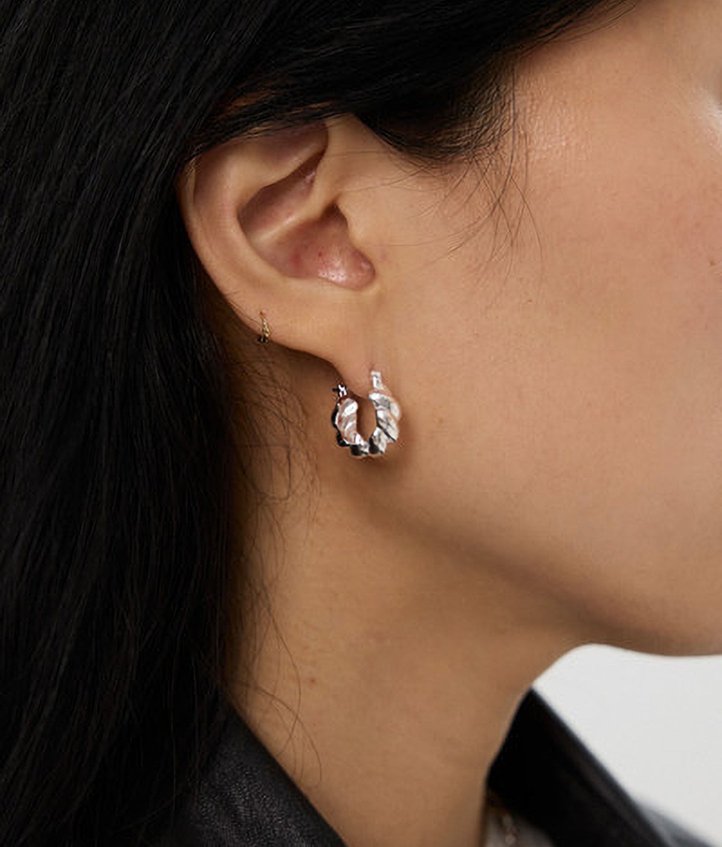 Close-up of an earring worn by a person with dark hair.