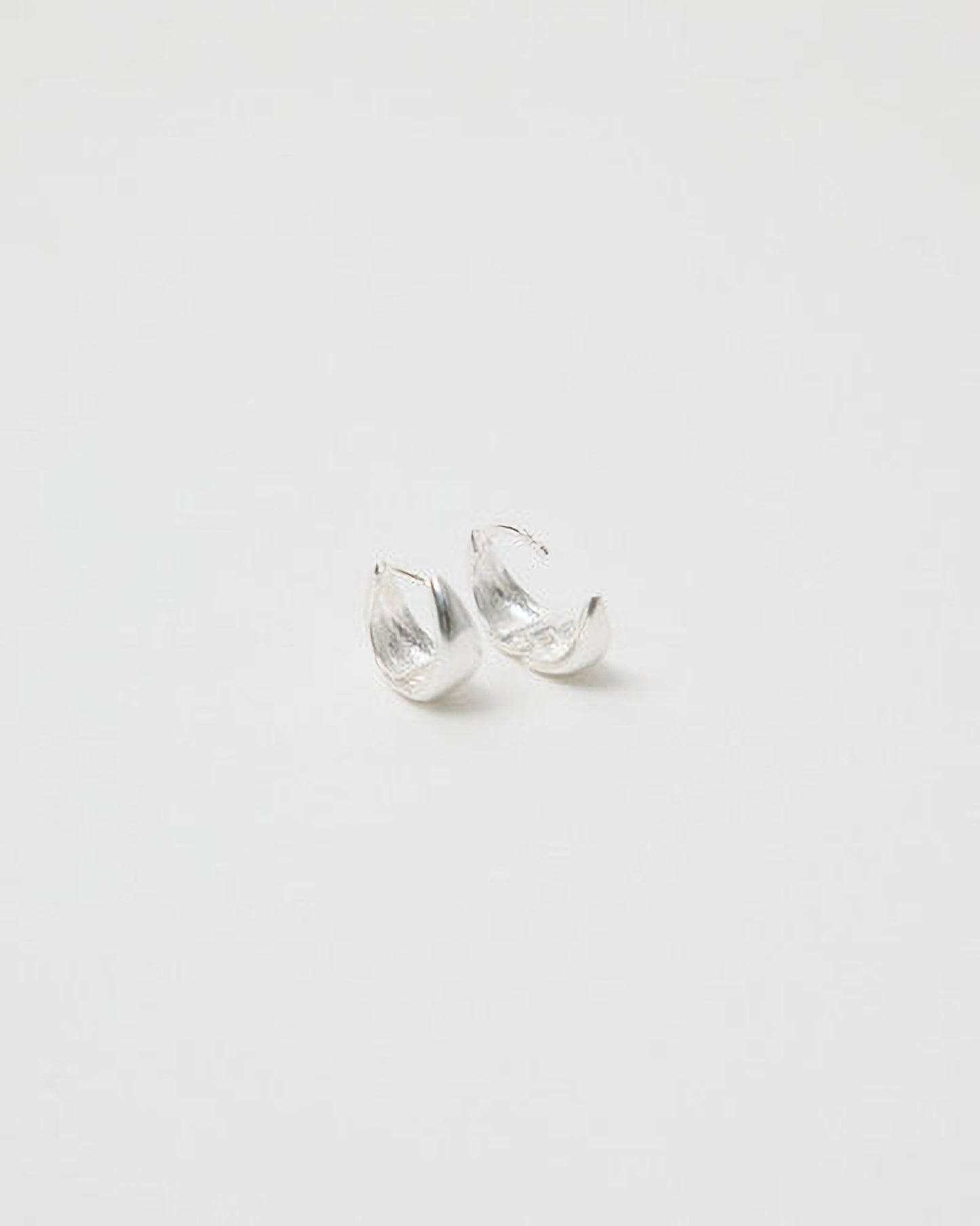 Pair of silver earrings on a light gray background
