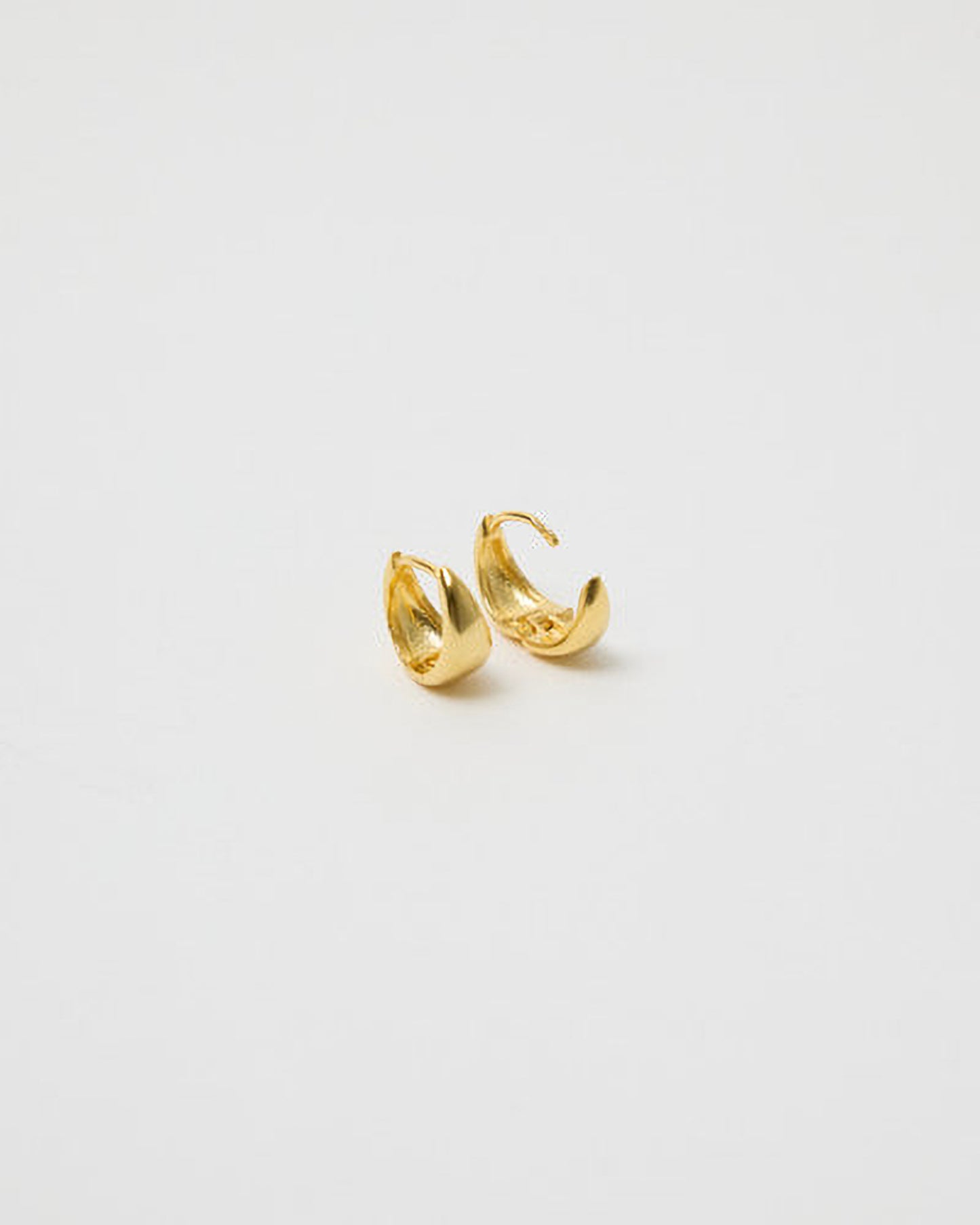 Gold hoop earrings on a light gray background