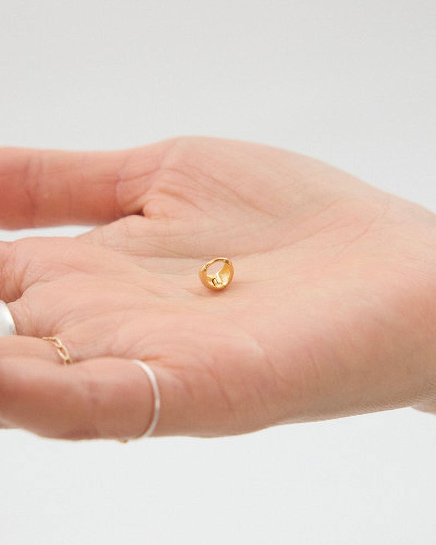 Gold ring on a hand with a plain background