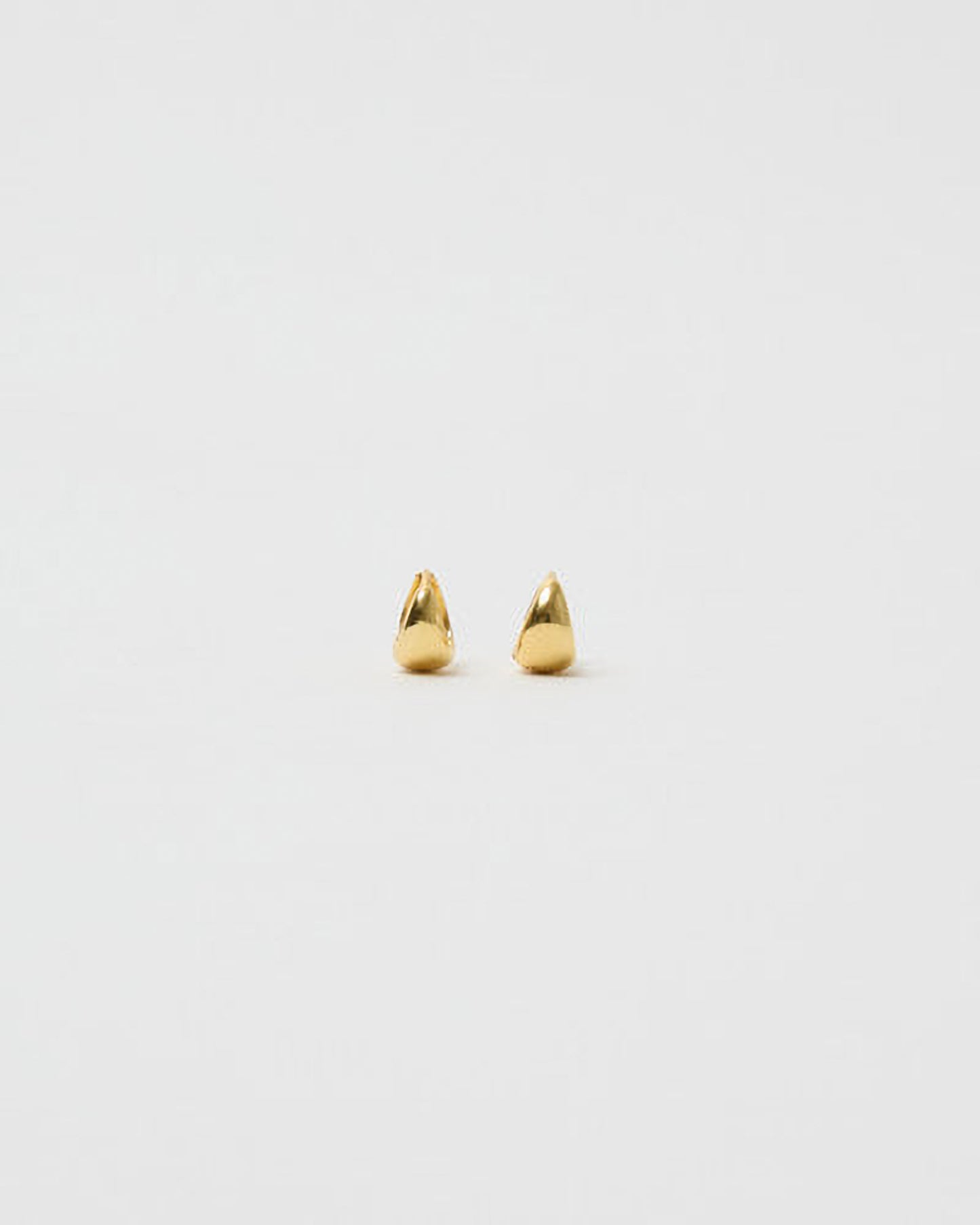 Pair of gold spike earrings on a light gray background