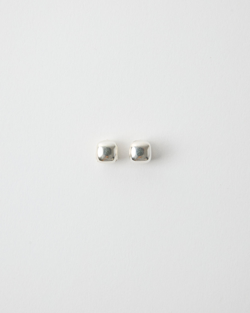 pair of sterling silver square stud earrings on white background, polished cube shape minimal jewelry, clean modern product shot