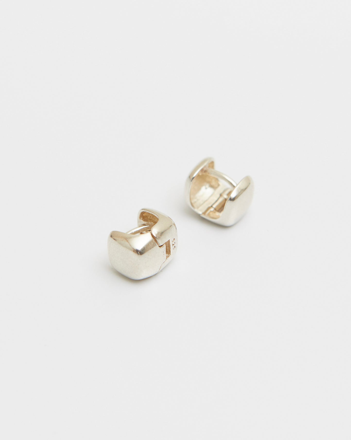 pair of sterling silver square stud earrings on white background, polished cube shape minimal jewelry, clean modern product shot